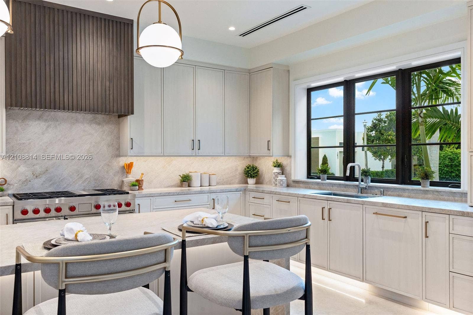 Kitchen featuring flat-panel cabinetry, a stone-surfaced island and countertops, a custom slatted wood range hood, a professional-style gas range, and large-format windows with black frames