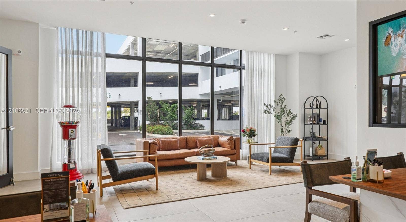 Floor-to-ceiling windows with dark metal framing and neutral-toned oversized floor tile