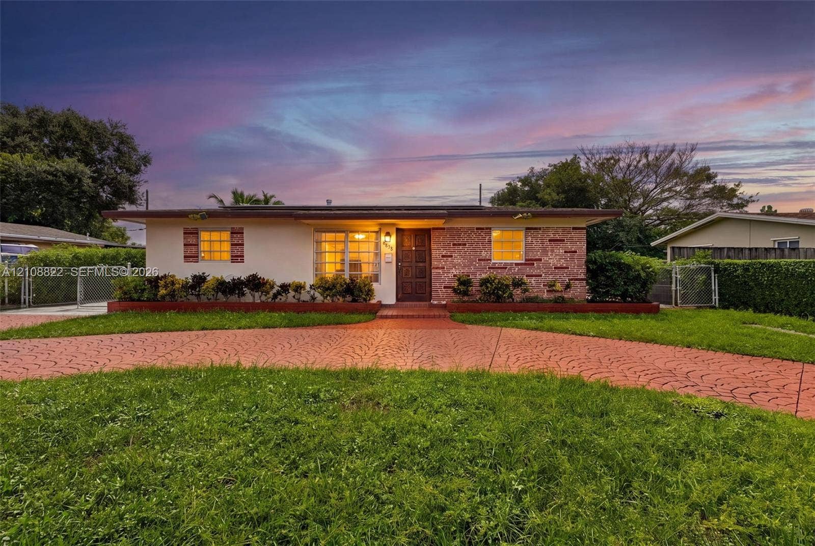 6838 SW 22nd Court, Miramar, FL 33023 Single-story exterior featuring a stamped concrete driveway, decorative stone facade, expansive lawn, and window shutters
