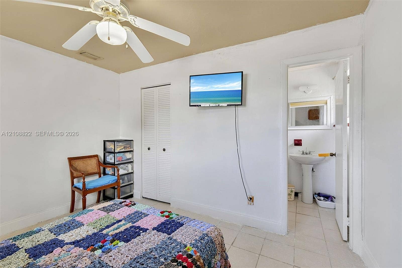 6838 SW 22nd Court, Miramar, FL 33023 Room featuring light-toned tile flooring, dual-panel closet doors, and a ceiling fan with integrated lighting