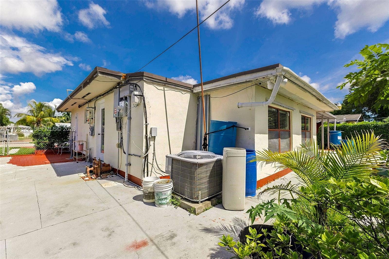 6838 SW 22nd Court, Miramar, FL 33023 Stucco exterior featuring concrete paved surfaces, window shutters, and central air conditioning unit