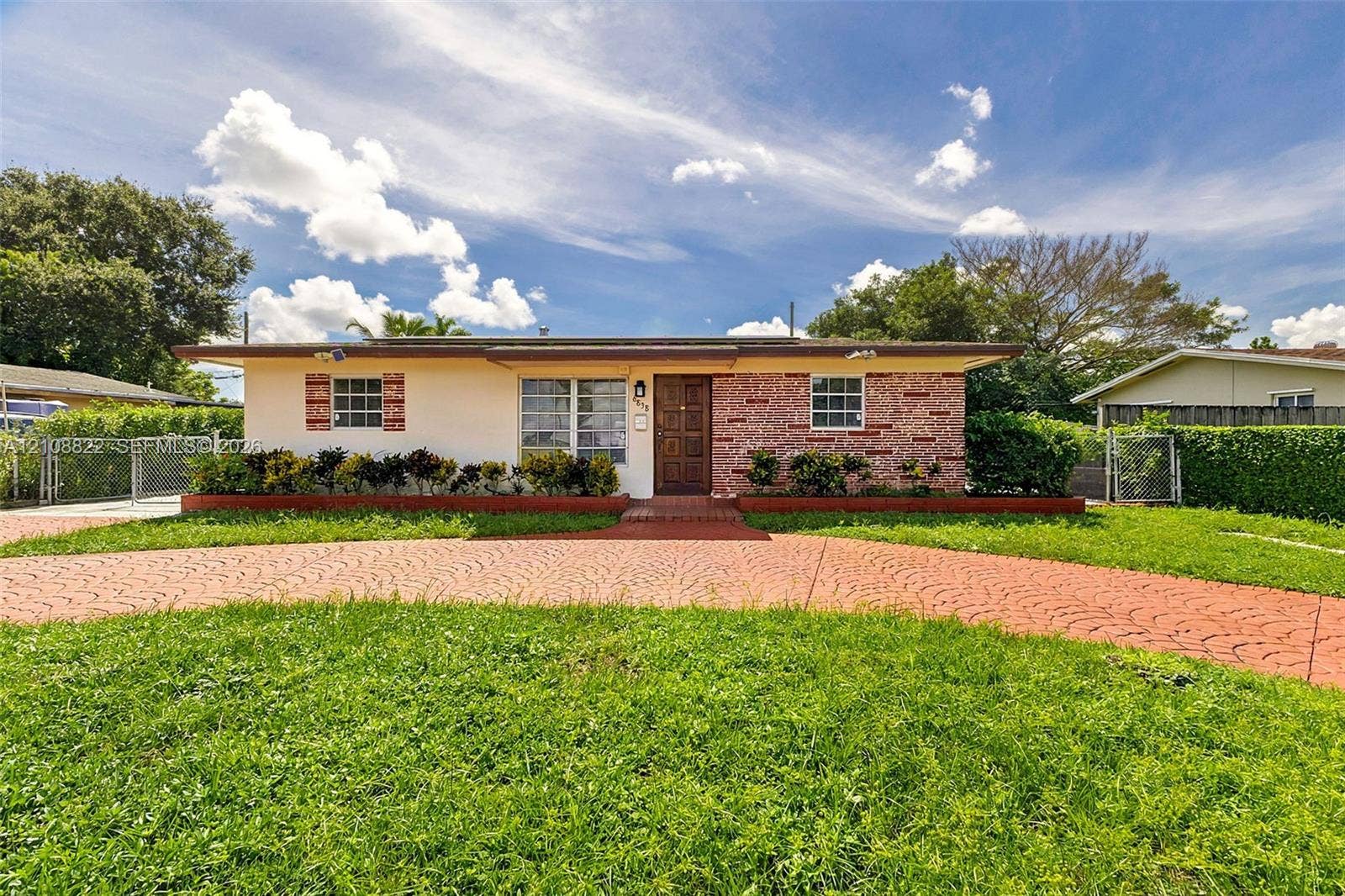 6838 SW 22nd Court, Miramar, FL 33023 Single-story exterior featuring a brick facade, stucco siding, a patterned concrete driveway, and exterior shutter accents