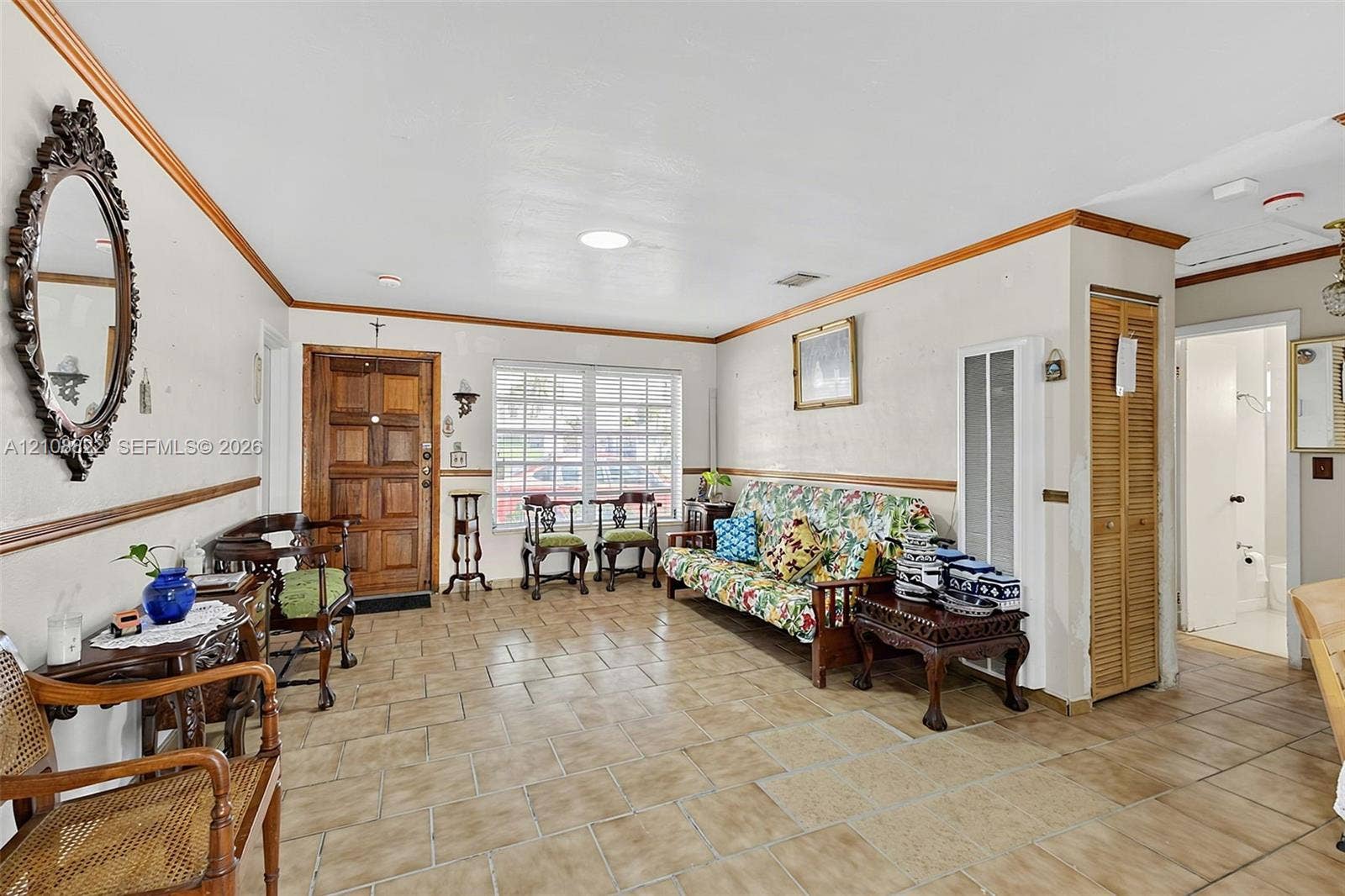 6838 SW 22nd Court, Miramar, FL 33023 Spacious interior featuring ceramic tile flooring, solid wood panel entry door, chair rail molding, and bi-fold louvered closet doors