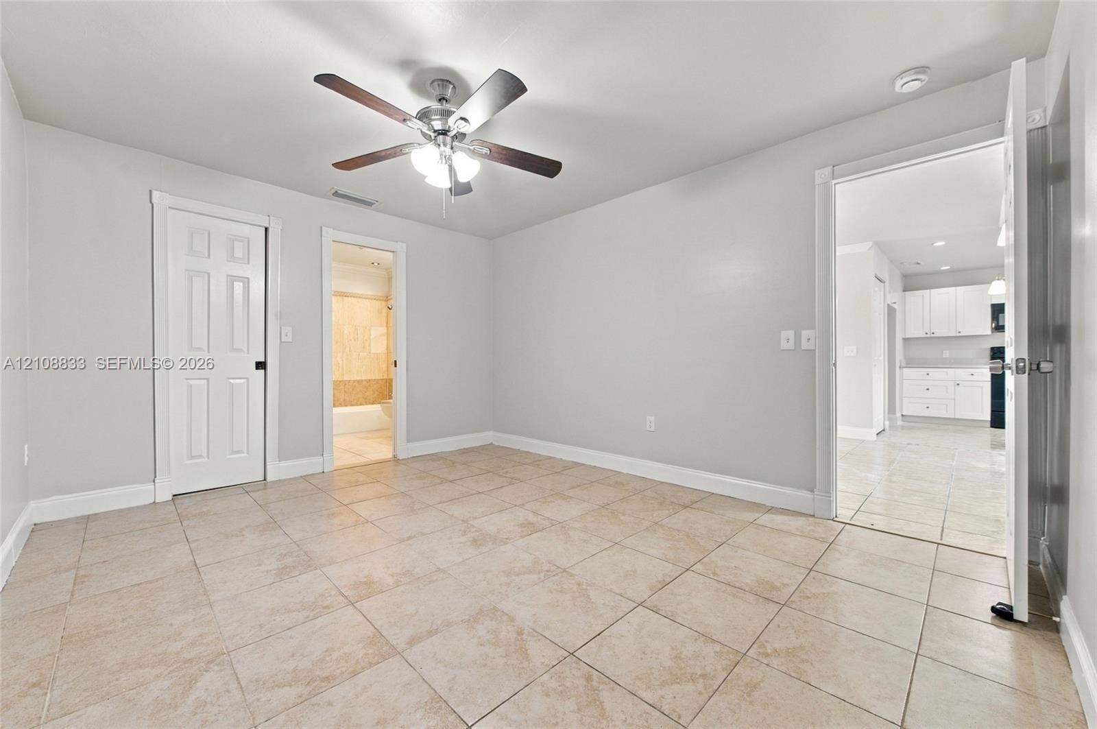 9611 Johnson Street, Pembroke Pines, FL 33024 Neutral-toned interior featuring ceramic tile flooring, a central ceiling fan with integrated lighting, and white six-panel doors