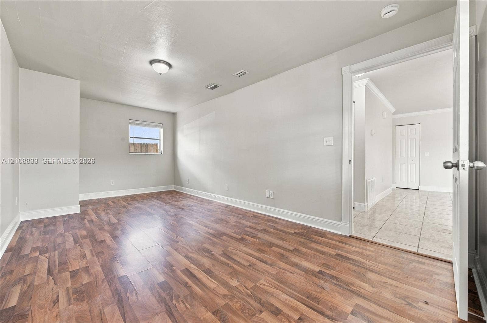 9611 Johnson Street, Pembroke Pines, FL 33024 Interior room featuring wood-finish flooring, neutral wall paint, and a single-pane window