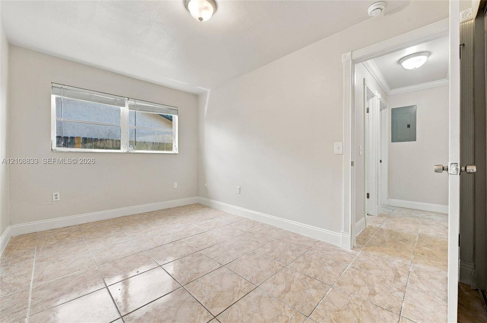 9611 Johnson Street, Pembroke Pines, FL 33024 Neutral-toned interior room featuring tile flooring, a dual-pane sliding window with horizontal blinds, and overhead lighting