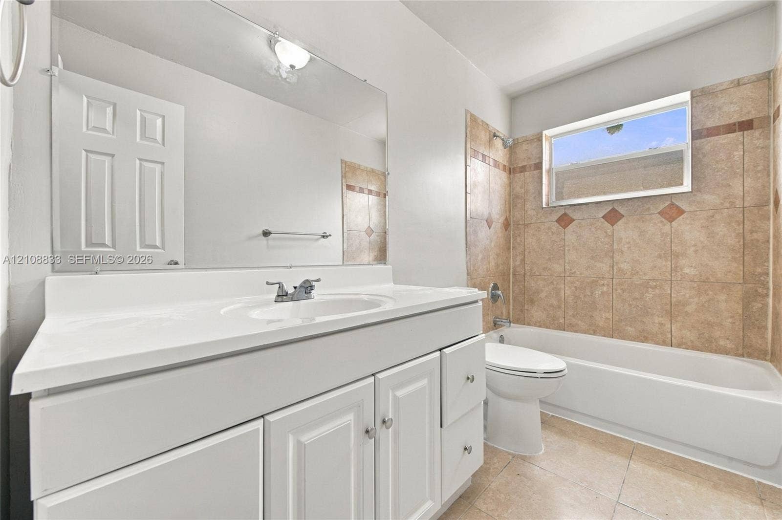 9611 Johnson Street, Pembroke Pines, FL 33024 Bathroom featuring a white vanity with an integrated sink, a full-width mirror, tile flooring, and a bathtub with decorative tile surround