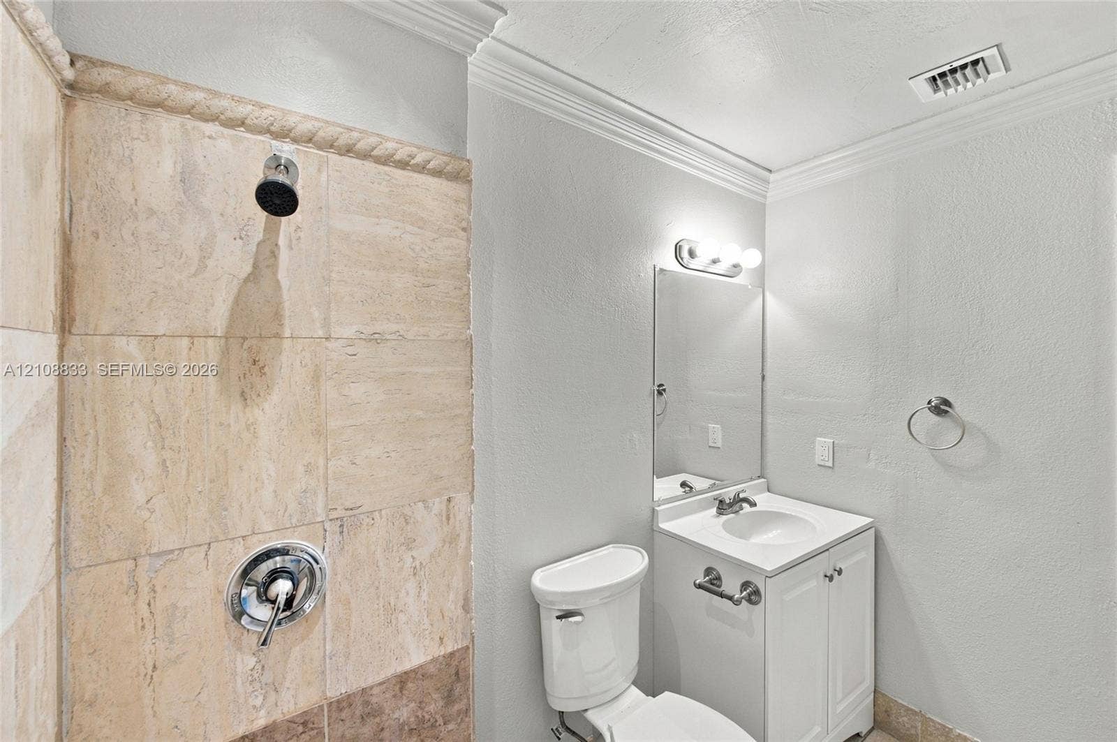 9611 Johnson Street, Pembroke Pines, FL 33024 Bathroom featuring stone-tiled shower walls with a decorative rope-style border, white vanity cabinetry with a stone countertop, an integrated sink, and polished chrome hardware