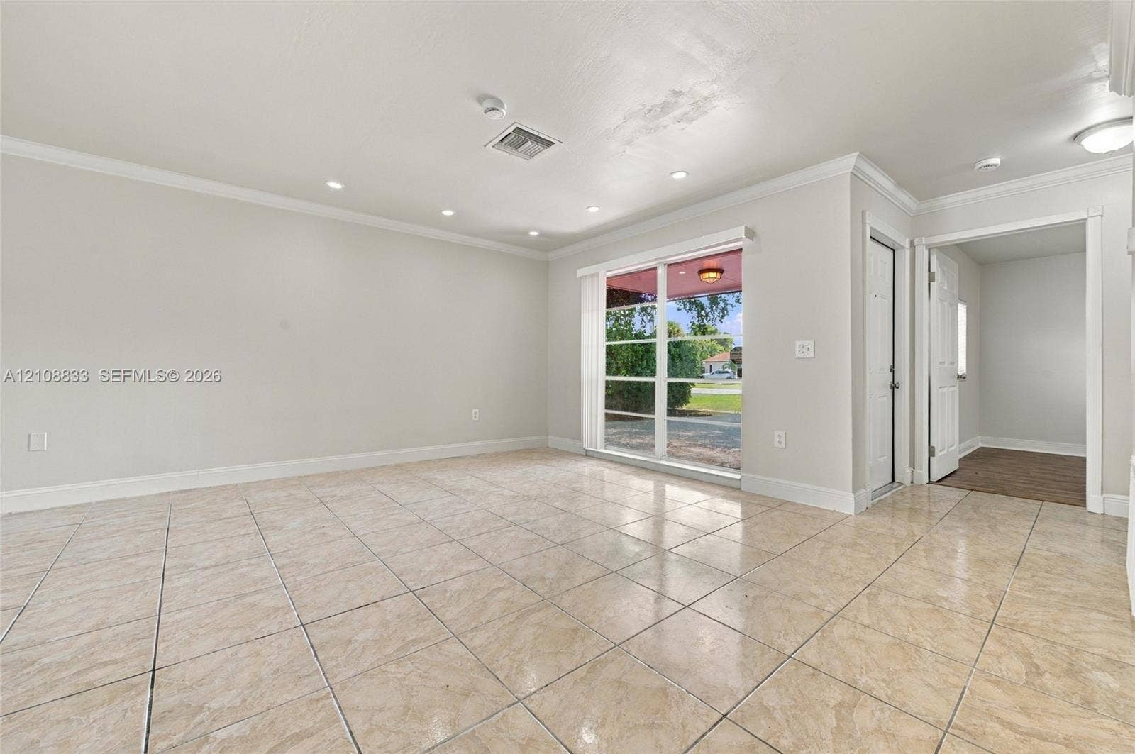 9611 Johnson Street, Pembroke Pines, FL 33024 Interior space featuring large-format tile flooring, recessed lighting, crown molding, and expansive sliding glass doors