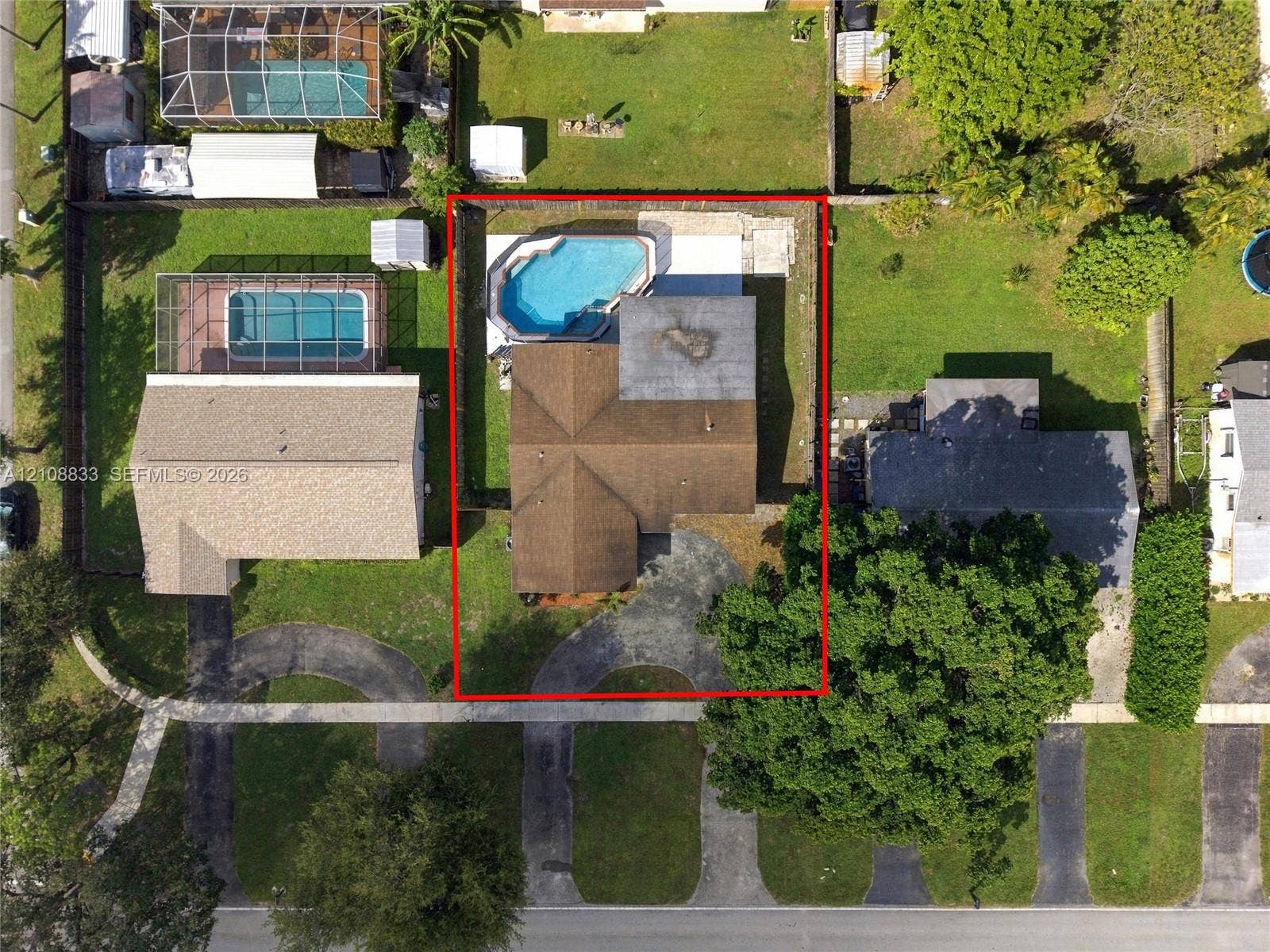 9611 Johnson Street, Pembroke Pines, FL 33024 Aerial perspective featuring an asphalt driveway, a shingled roof, and a backyard swimming pool with a concrete deck