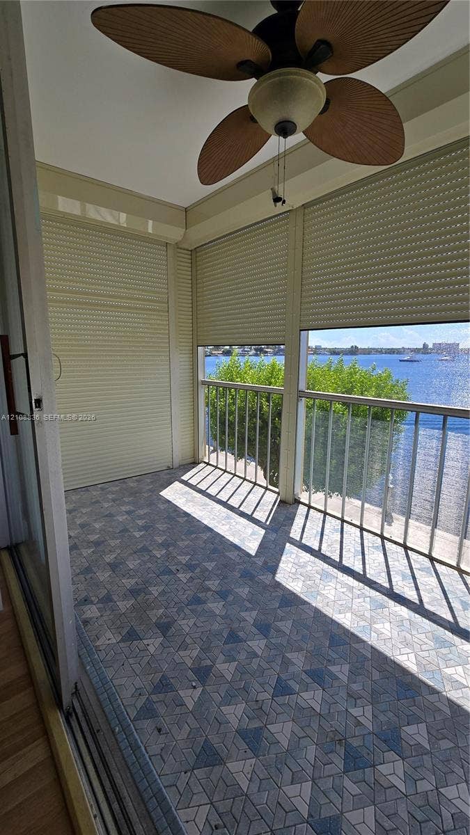3000 Marcos Drive, #P304, Aventura, FL 33160 Covered balcony featuring patterned tile flooring, retractable privacy shutters, metal railings, and an integrated ceiling fan