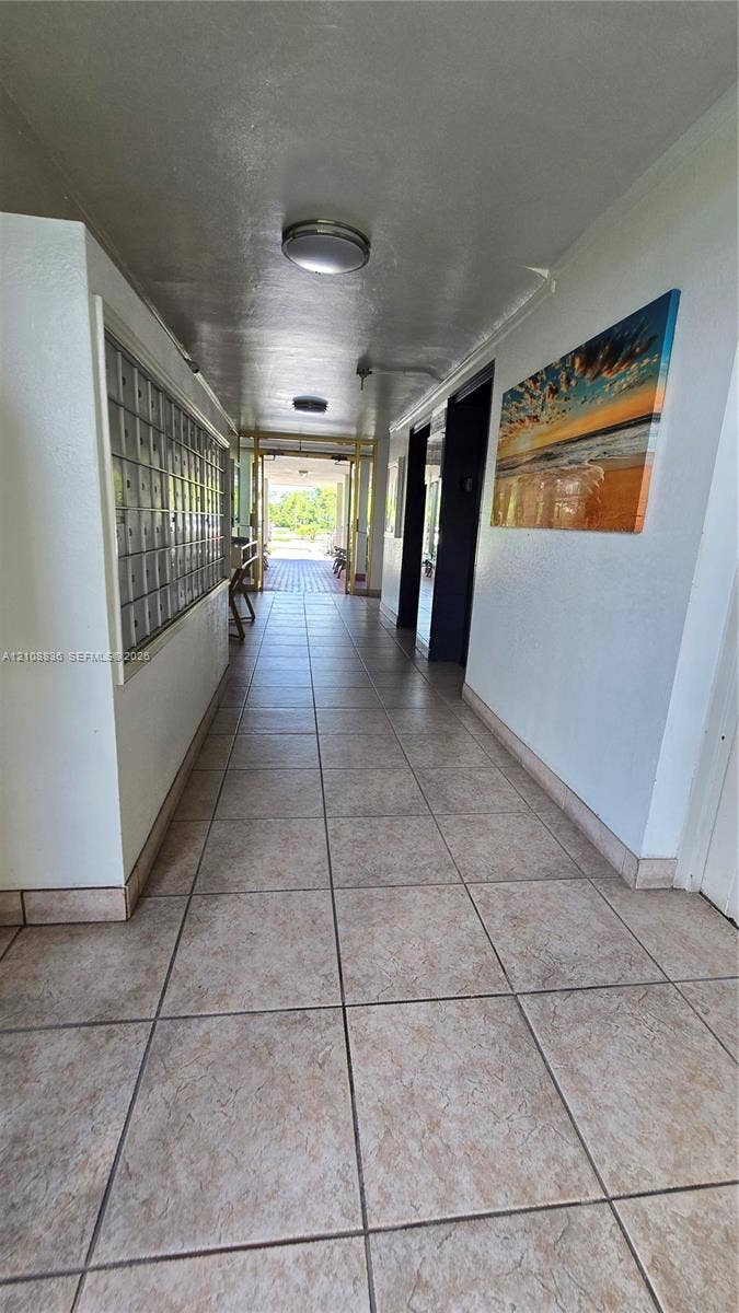 3000 Marcos Drive, #P304, Aventura, FL 33160 Interior hallway featuring ceramic tile flooring, flush-mount ceiling lighting, and built-in wall-mounted mailboxes