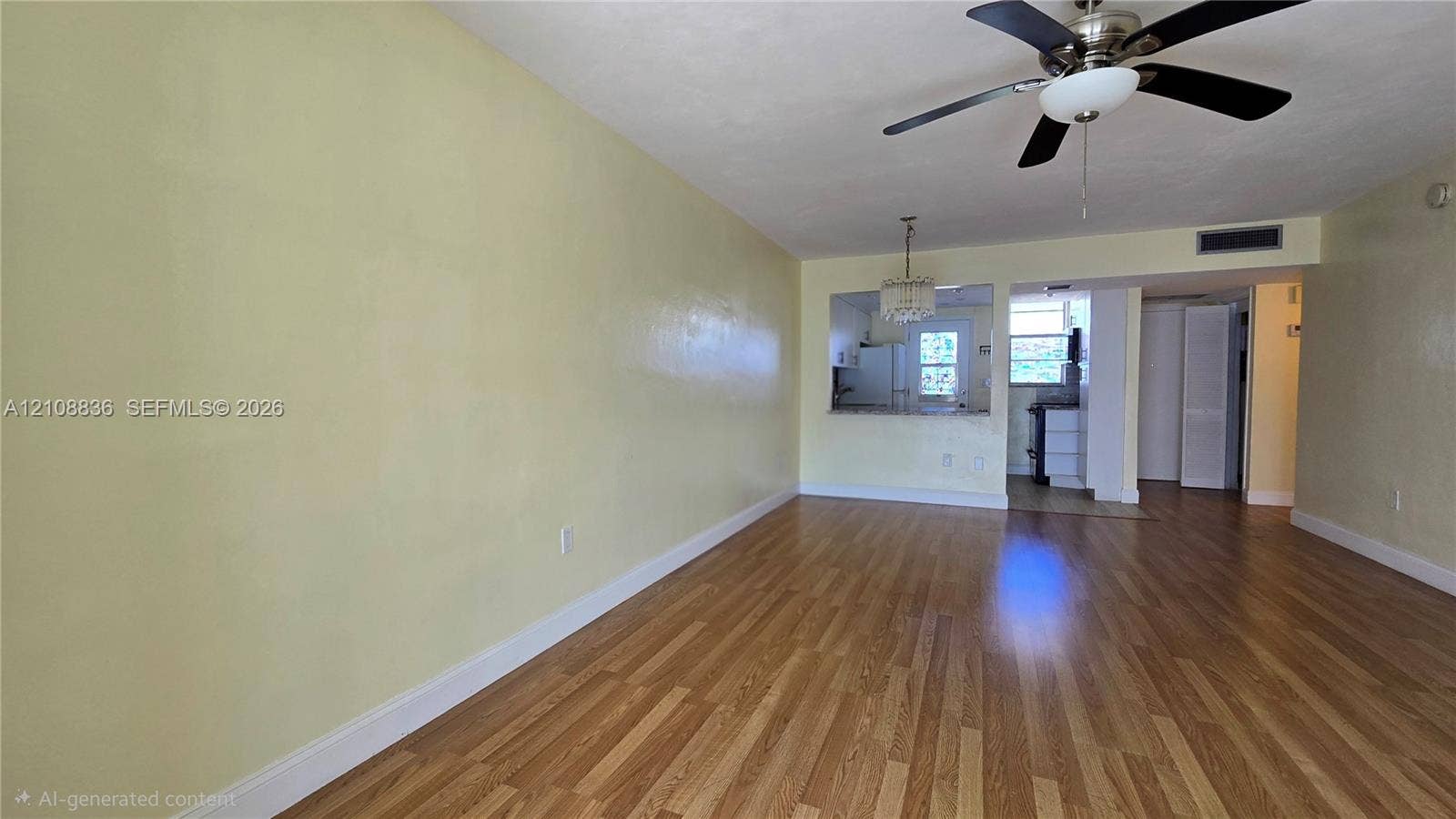 3000 Marcos Drive, #P304, Aventura, FL 33160 Open-concept interior featuring wood-finish flooring, a ceiling fan with integrated lighting, a decorative hanging pendant fixture, and a pass-through opening
