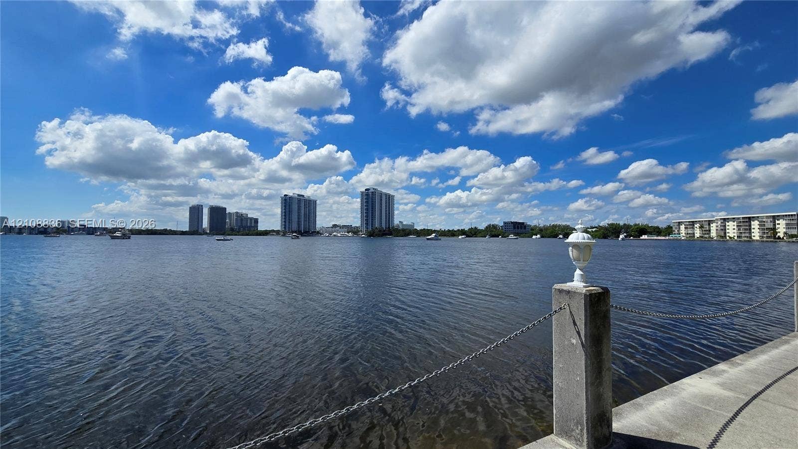 3000 Marcos Drive, #P304, Aventura, FL 33160 Waterfront bulkhead featuring stone masonry, decorative finial post, and metal chain railing