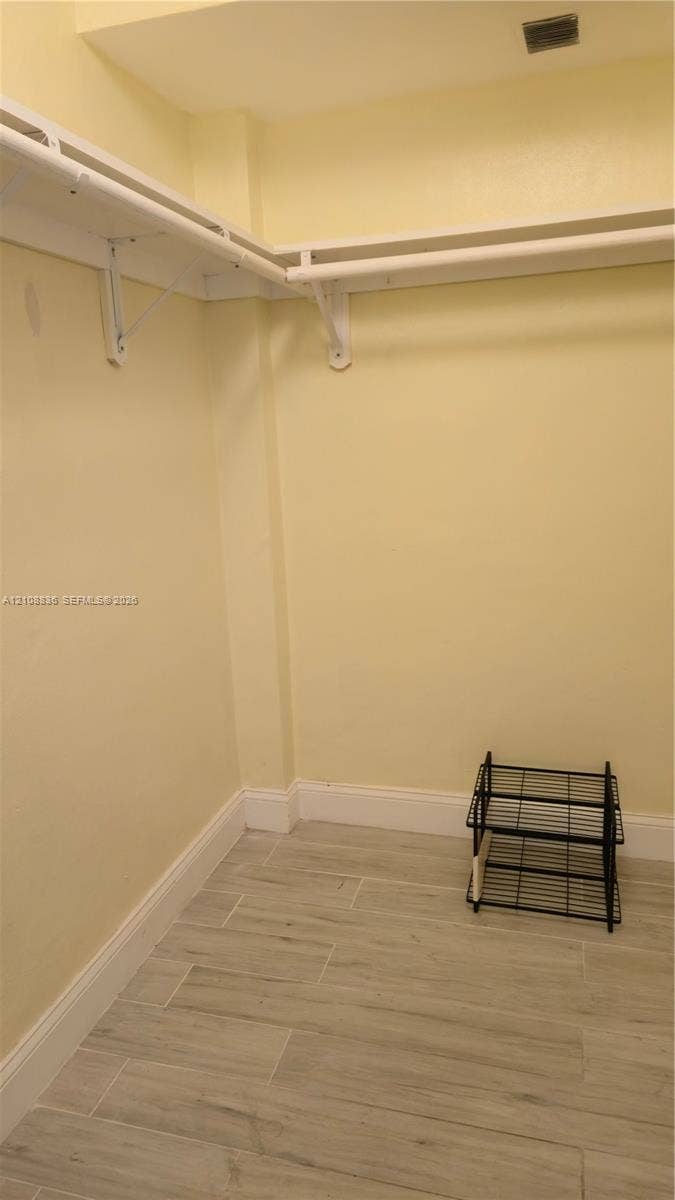 3000 Marcos Drive, #P304, Aventura, FL 33160 Walk-in storage area featuring wood-finish tile flooring and wraparound white shelving