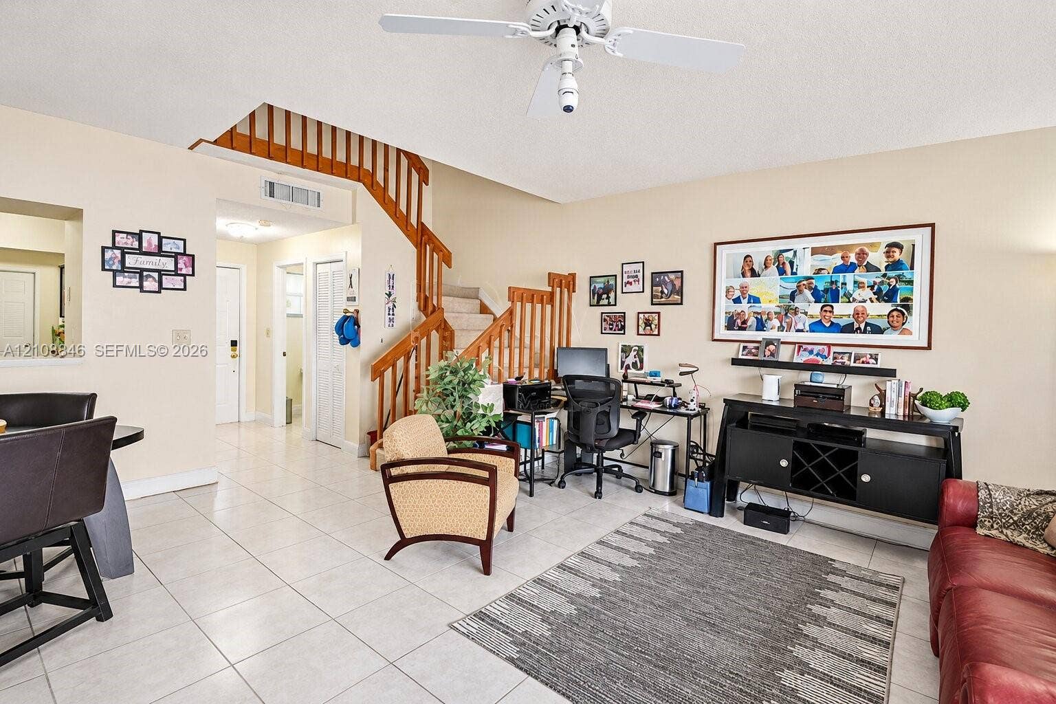 11827 SW 99th Lane, Miami, FL 33186 Open-concept interior featuring oversized tile flooring, a staircase with wooden railings, and a ceiling fan