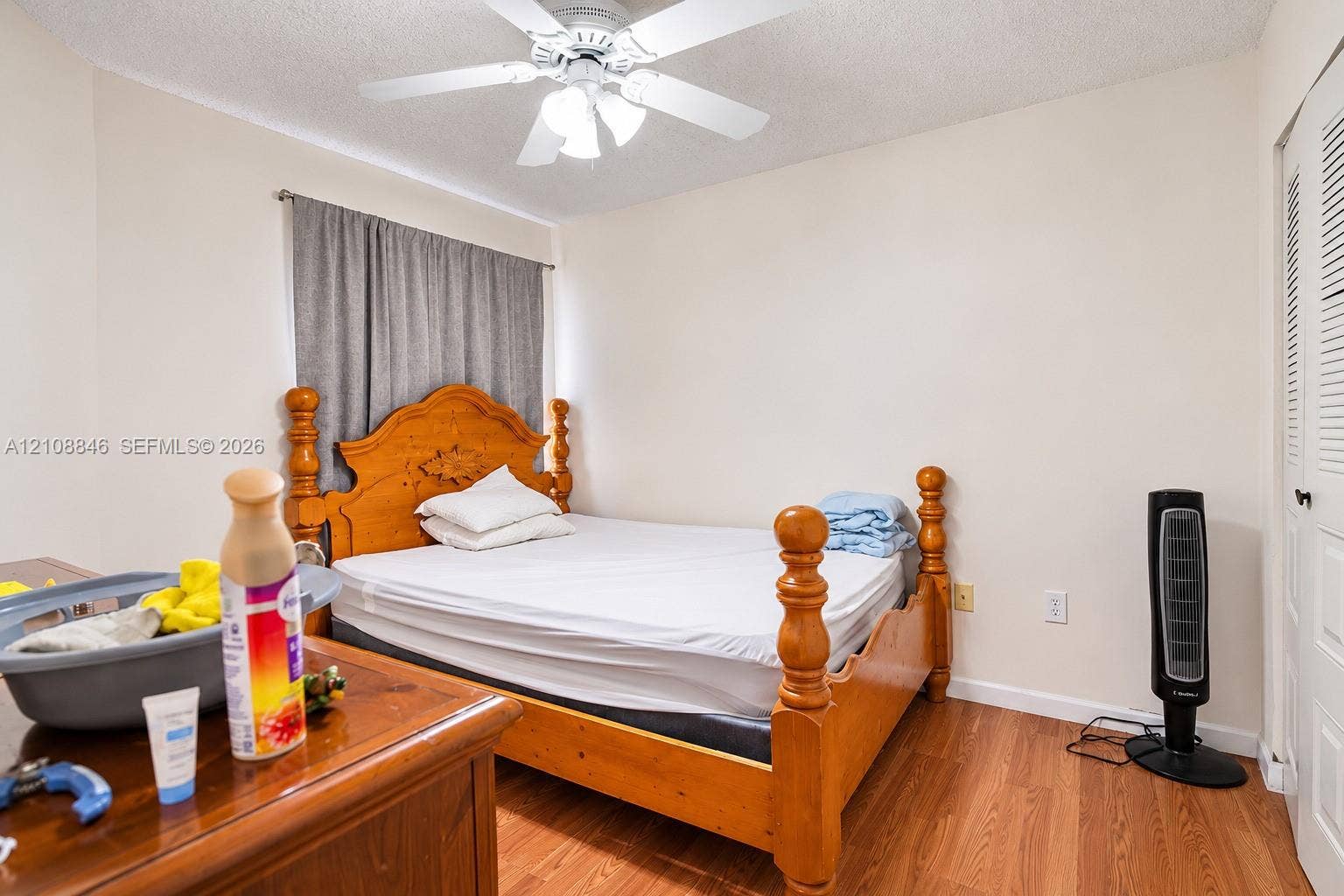 11827 SW 99th Lane, Miami, FL 33186 Bedroom interior featuring wood-finish flooring, white walls, a ceiling fan with integrated lighting, and louvered closet doors