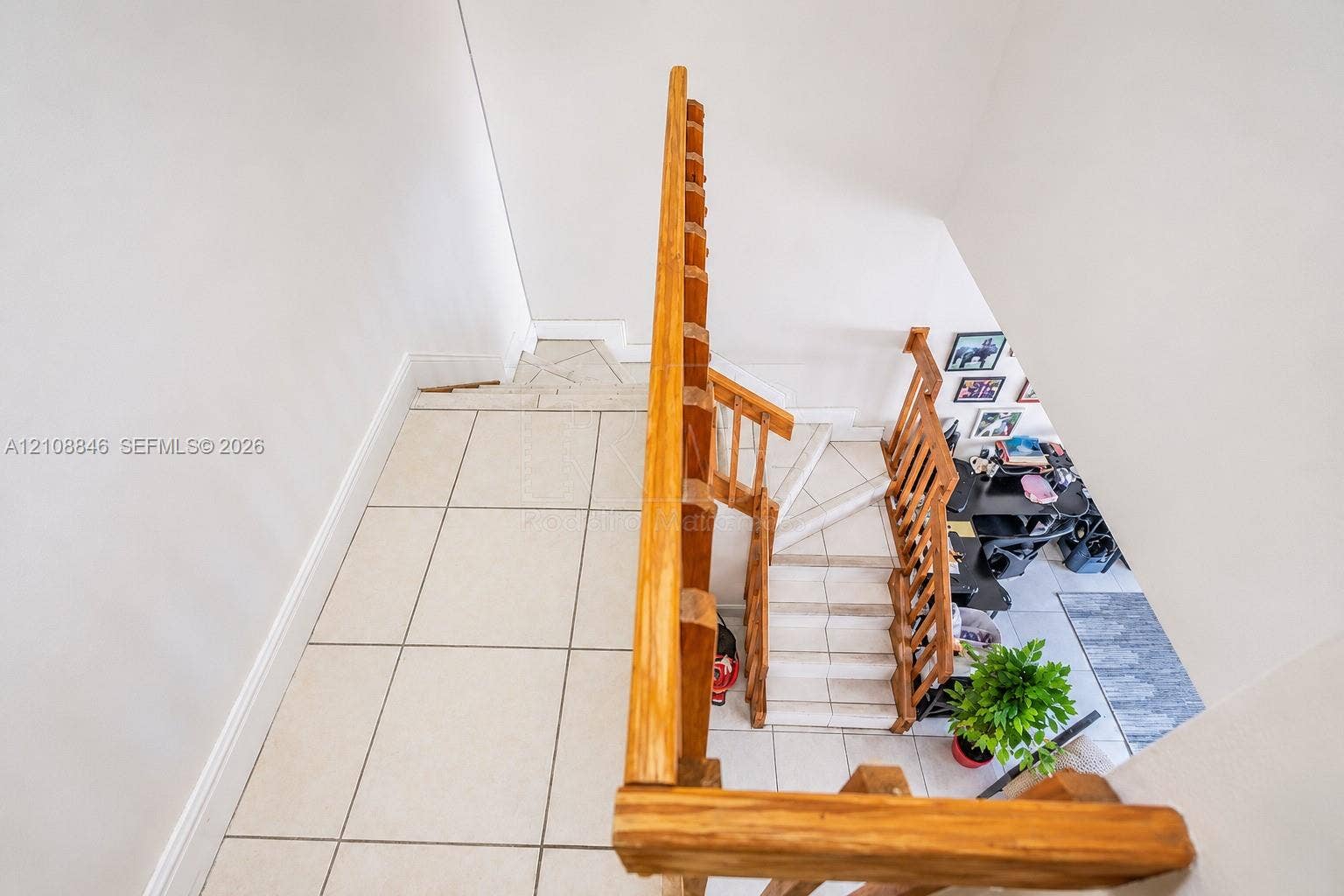 11827 SW 99th Lane, Miami, FL 33186 Staircase featuring natural wood-finish railings, tile flooring, and vertical balusters