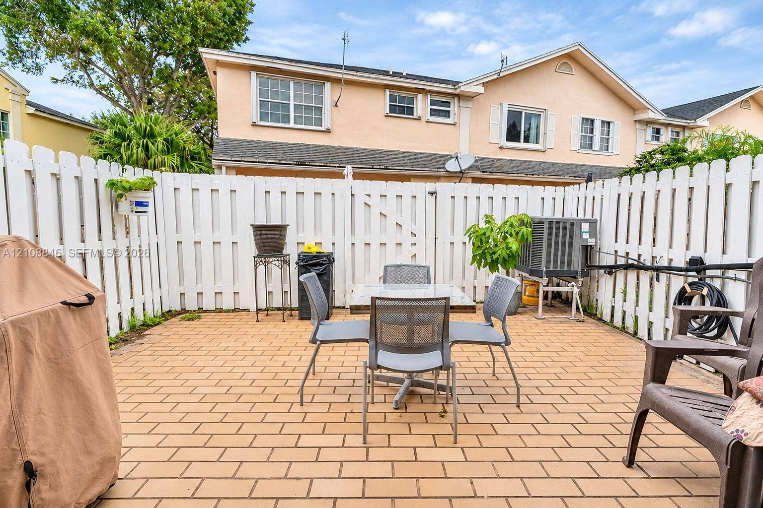 11827 SW 99th Lane, Miami, FL 33186 Private courtyard featuring light-toned paved flooring and a full-perimeter white vinyl fence