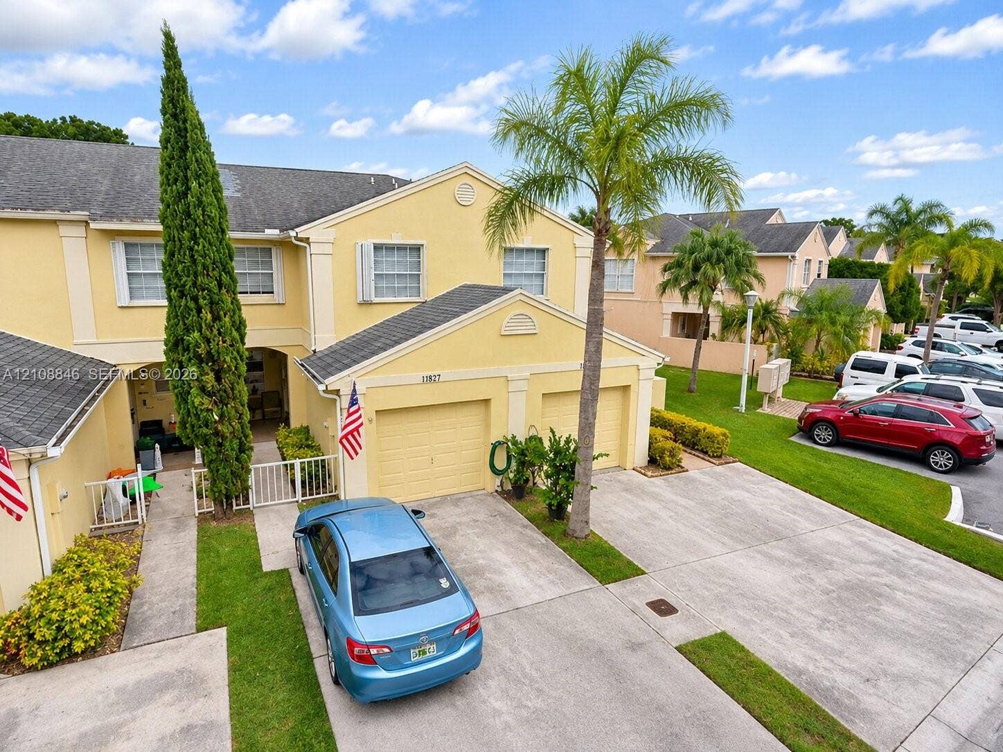 11827 SW 99th Lane, Miami, FL 33186 Two-story exterior featuring light-colored stucco siding, a multi-gabled shingle roof, a two-car garage, and a private paved driveway