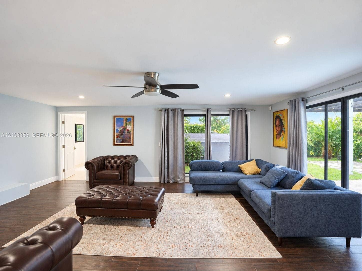 Spacious room featuring wood-finish tile flooring, recessed lighting, a ceiling fan, and large sliding glass doors