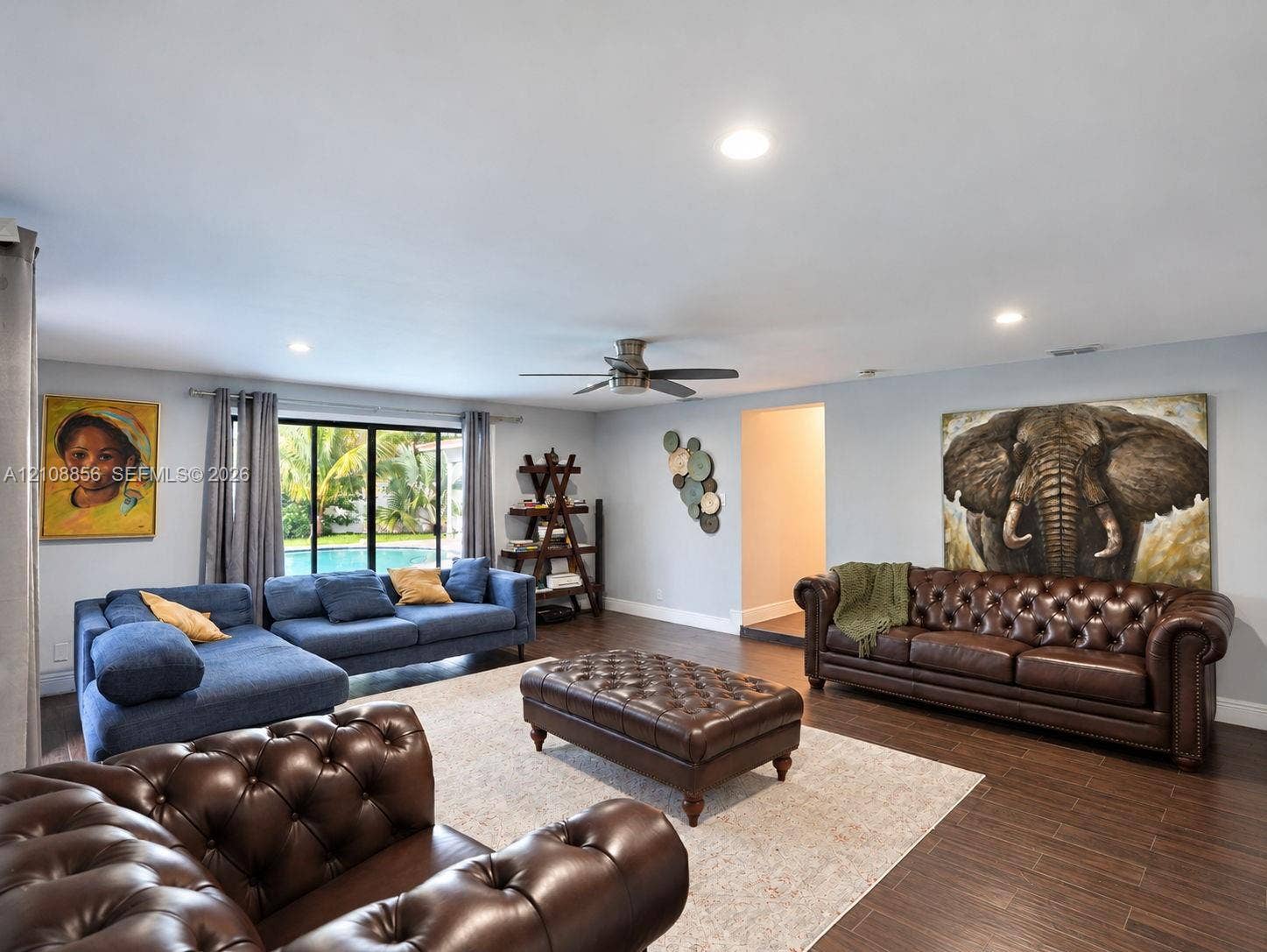 Open-concept living space featuring wood-finish flooring, recessed lighting, and a ceiling fan