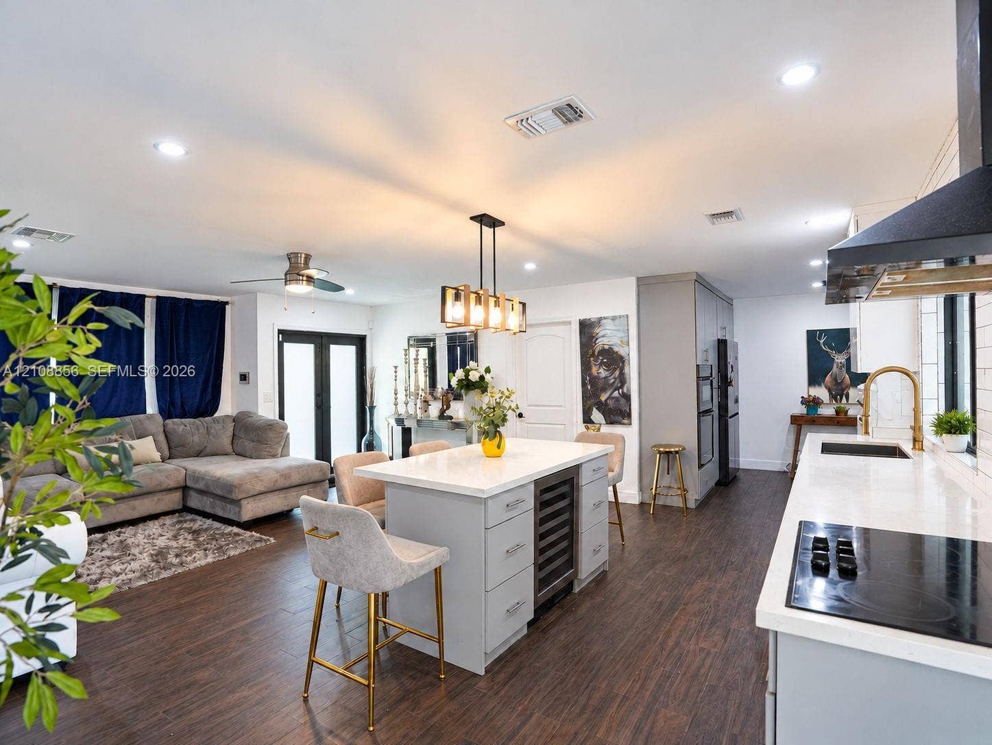 Kitchen featuring a central island with a built-in wine refrigerator, quartz countertops, wood-finish flooring, recessed lighting, and a modern industrial-style pendant light