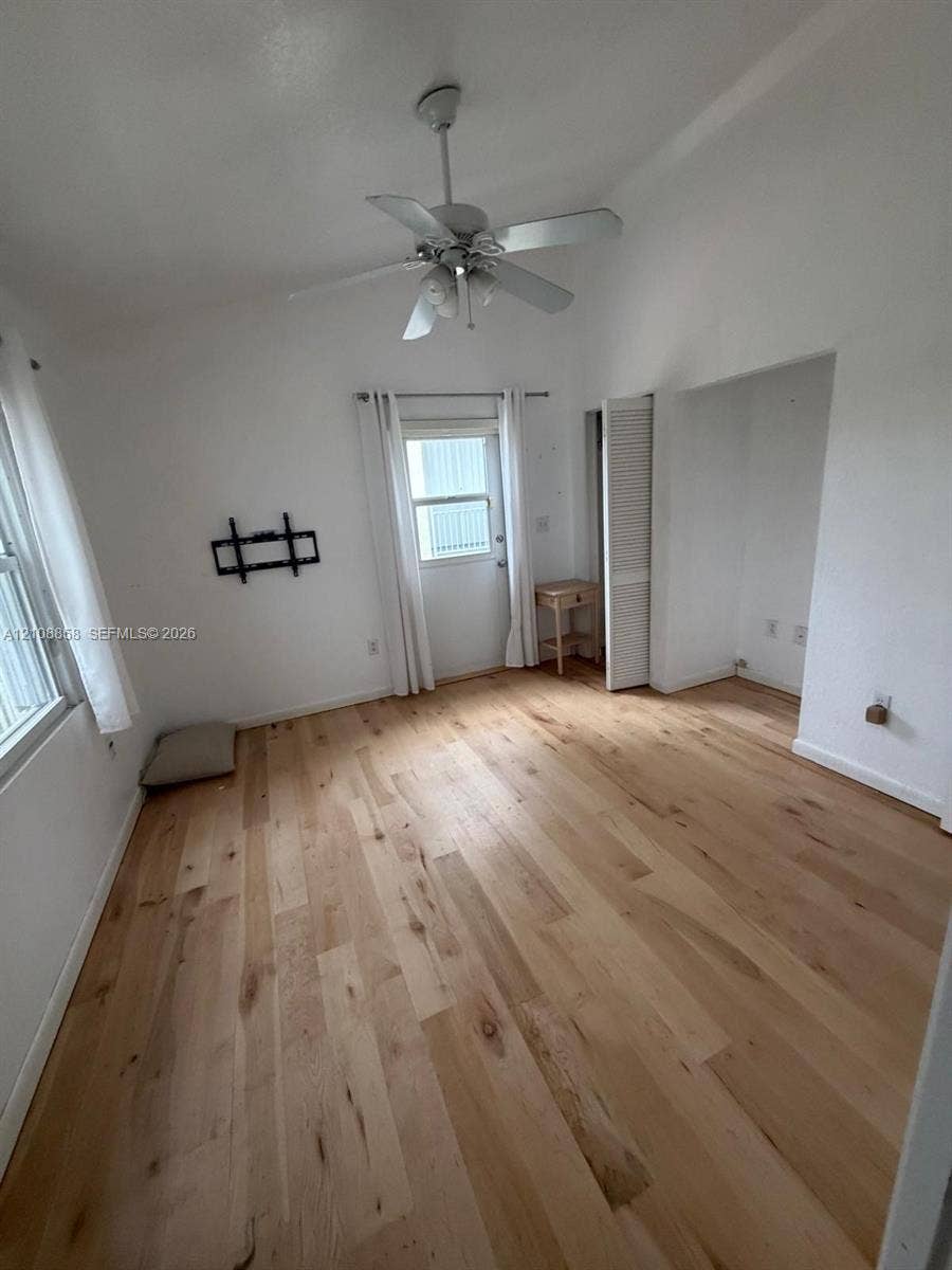 Vaulted ceilings, wood-finish flooring, ceiling fan with integrated lighting, and louvered closet doors