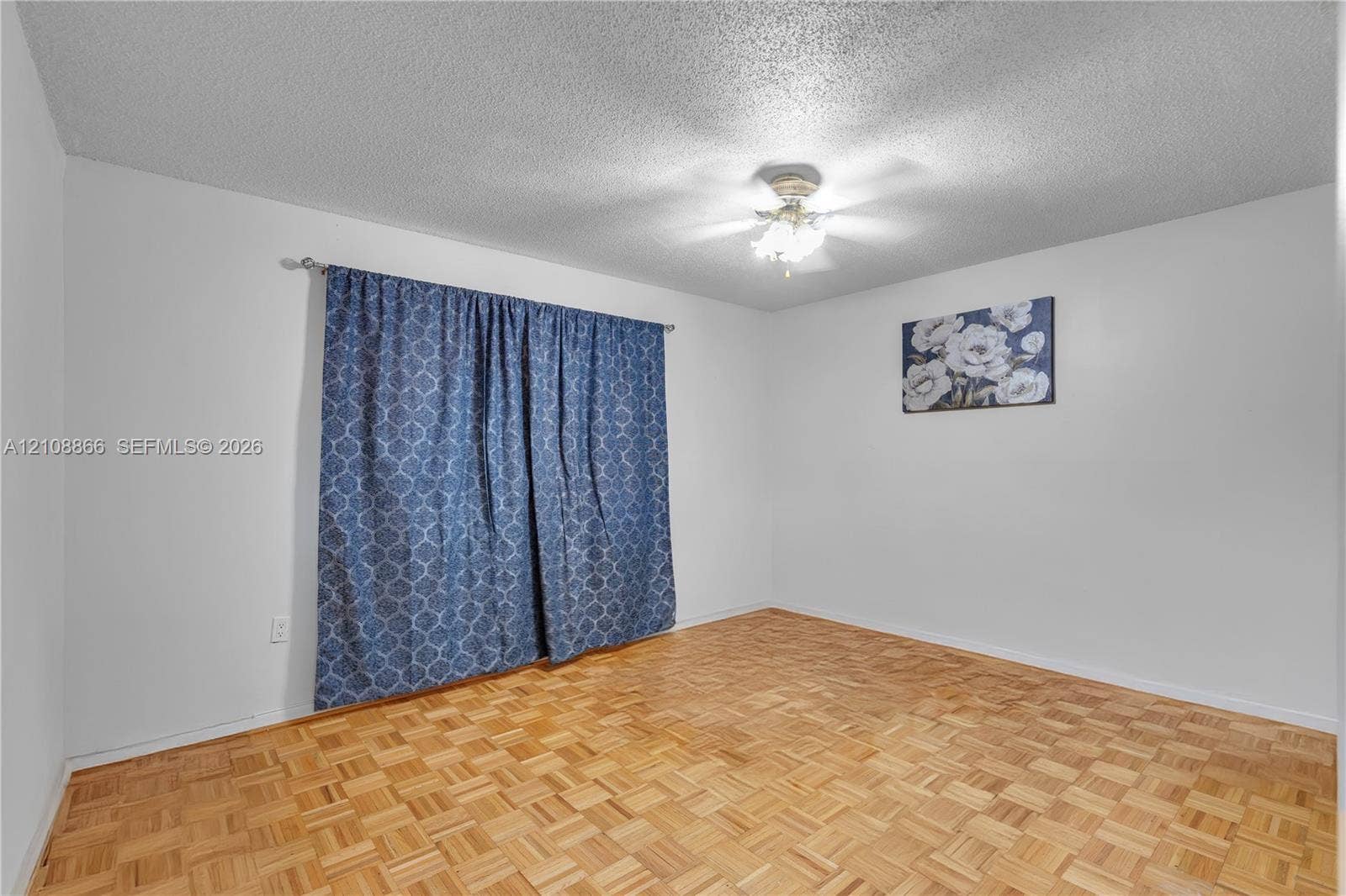 10859 NW 7th Street, #21-18, Miami, FL 33172 Parquet wood-finish flooring, textured ceiling, and a central ceiling fan with multi-light fixture