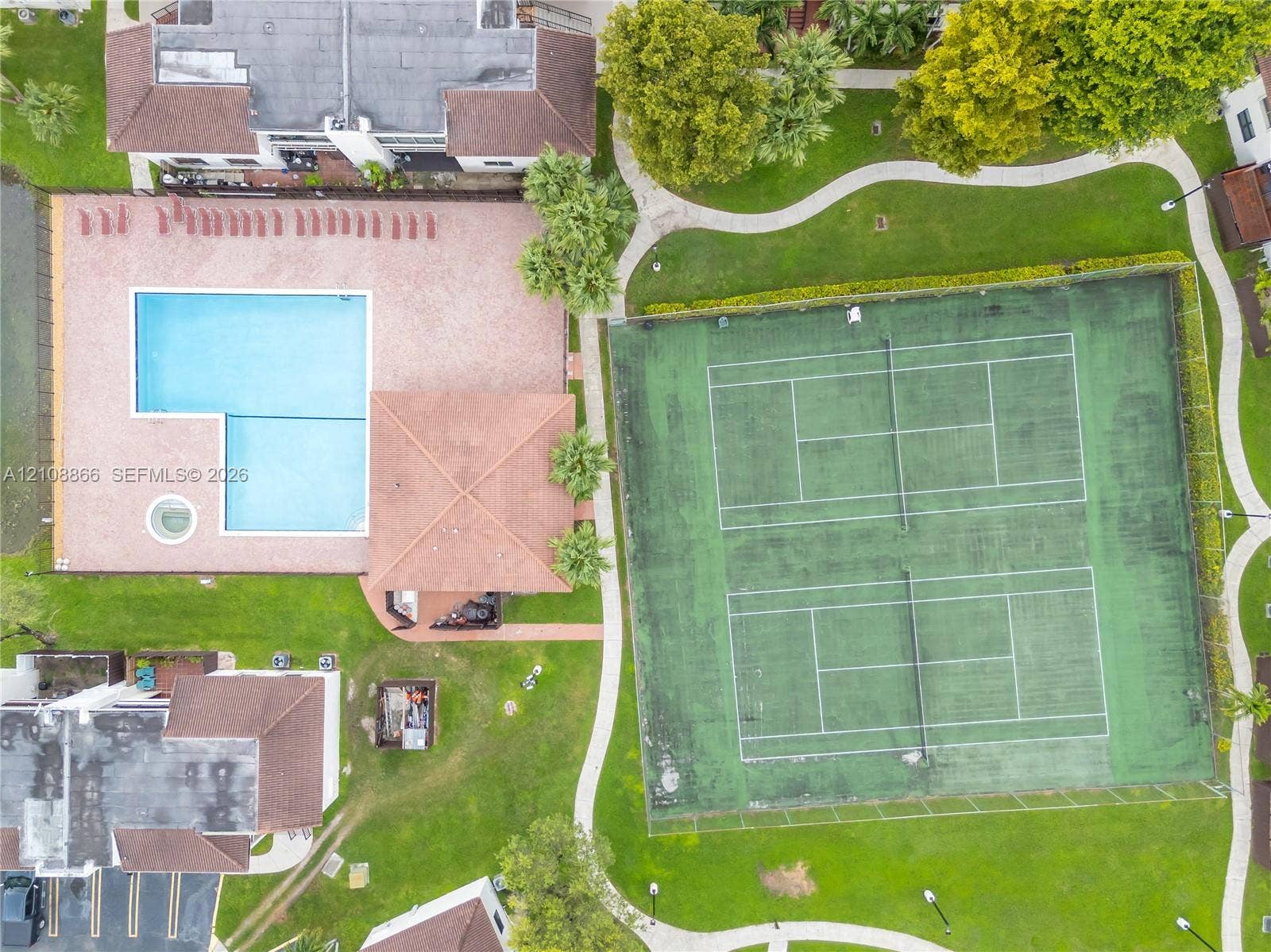 10859 NW 7th Street, #21-18, Miami, FL 33172 Community amenities featuring two full-sized tennis courts, an L-shaped swimming pool with an attached spa, a paved pool deck, and landscaped green space