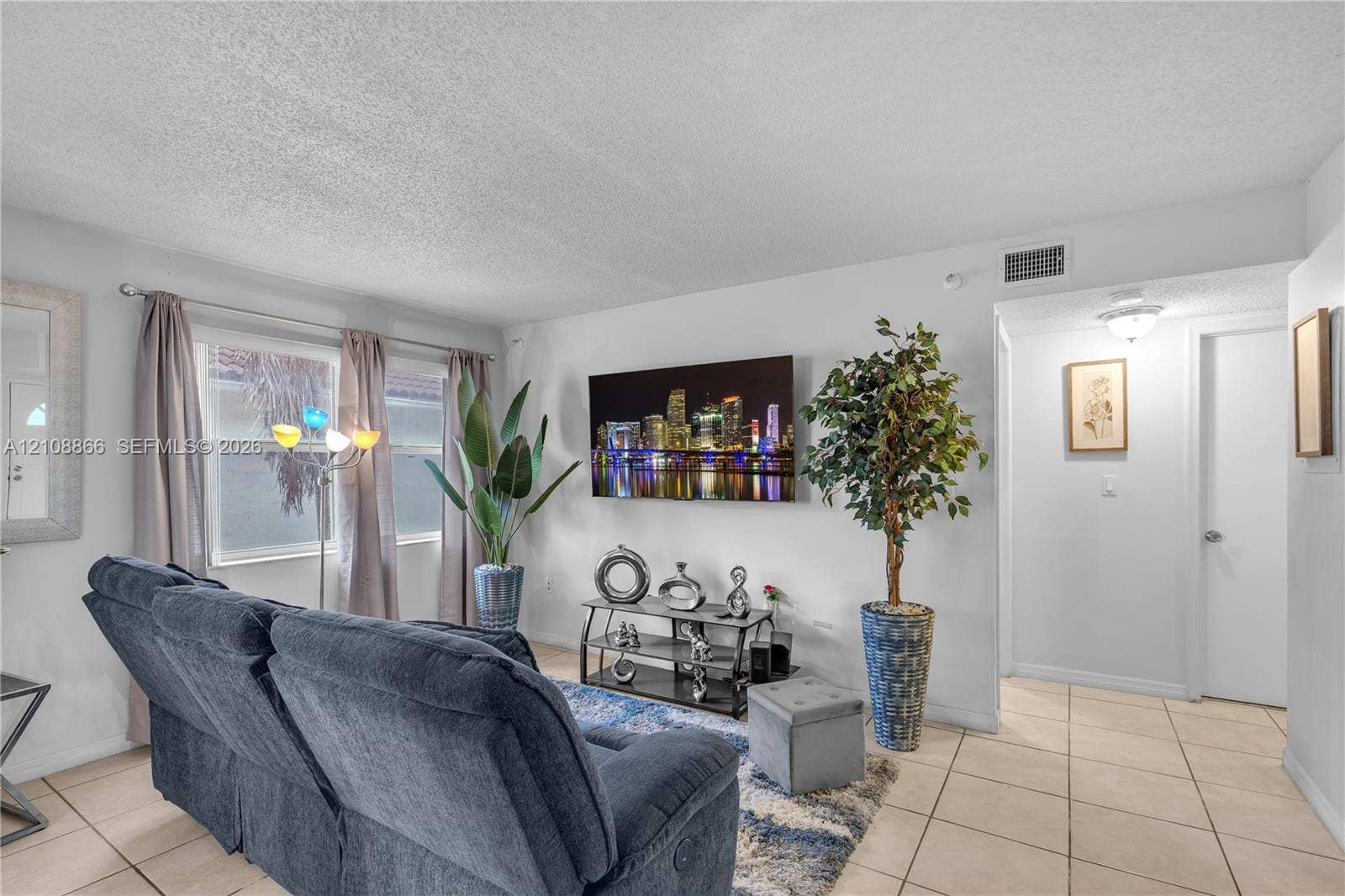 10859 NW 7th Street, #21-18, Miami, FL 33172 Living area featuring neutral wall paint, tile flooring, and dual-pane windows