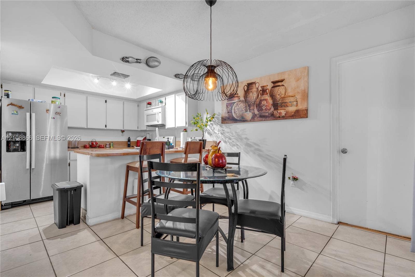 10859 NW 7th Street, #21-18, Miami, FL 33172 Kitchen featuring white cabinetry, wood-surface breakfast bar, recessed lighting, and tile flooring