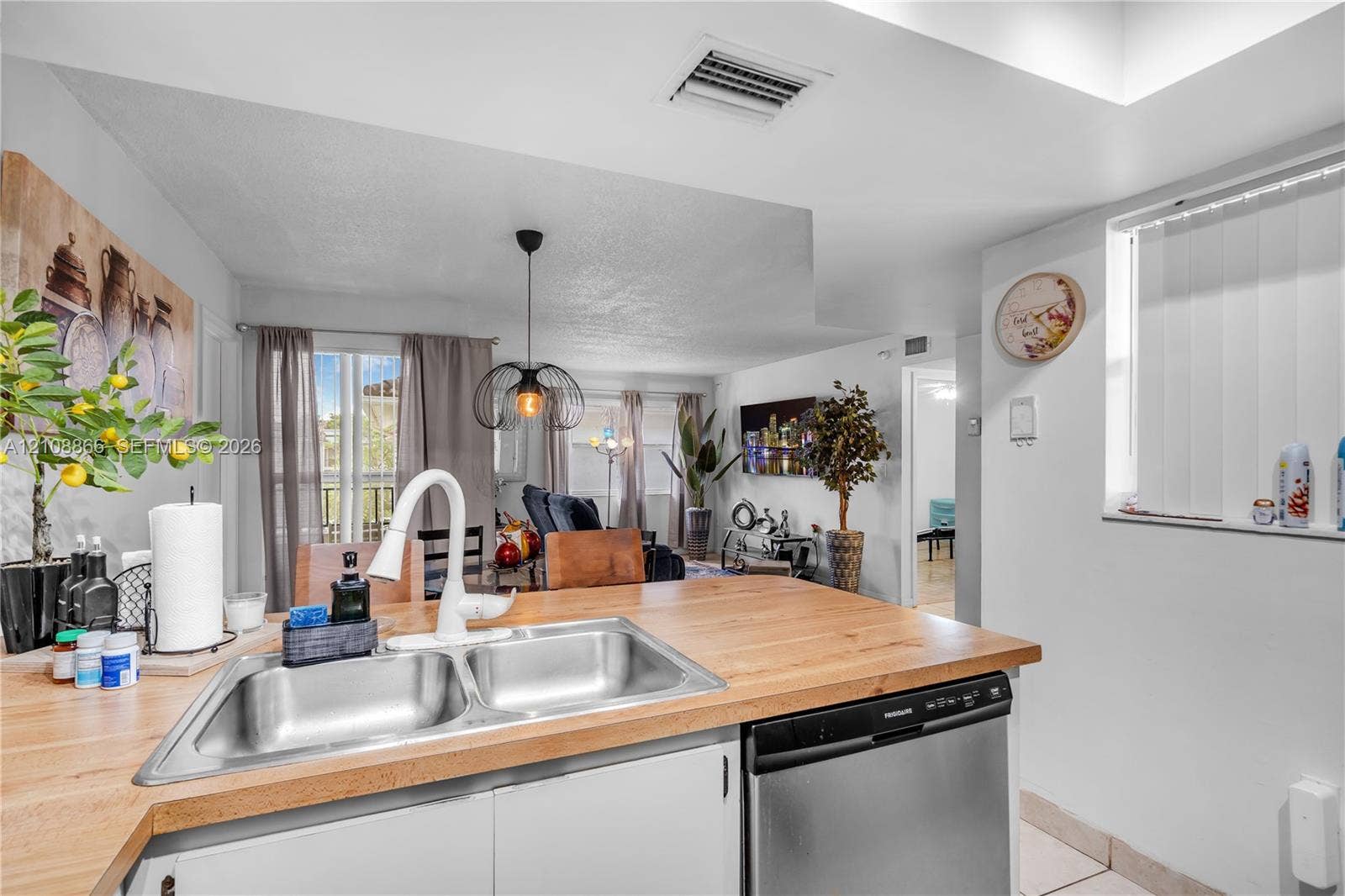 10859 NW 7th Street, #21-18, Miami, FL 33172 Kitchen featuring a wood-finish countertop, dual-basin stainless steel sink, gooseneck faucet, and stainless steel dishwasher