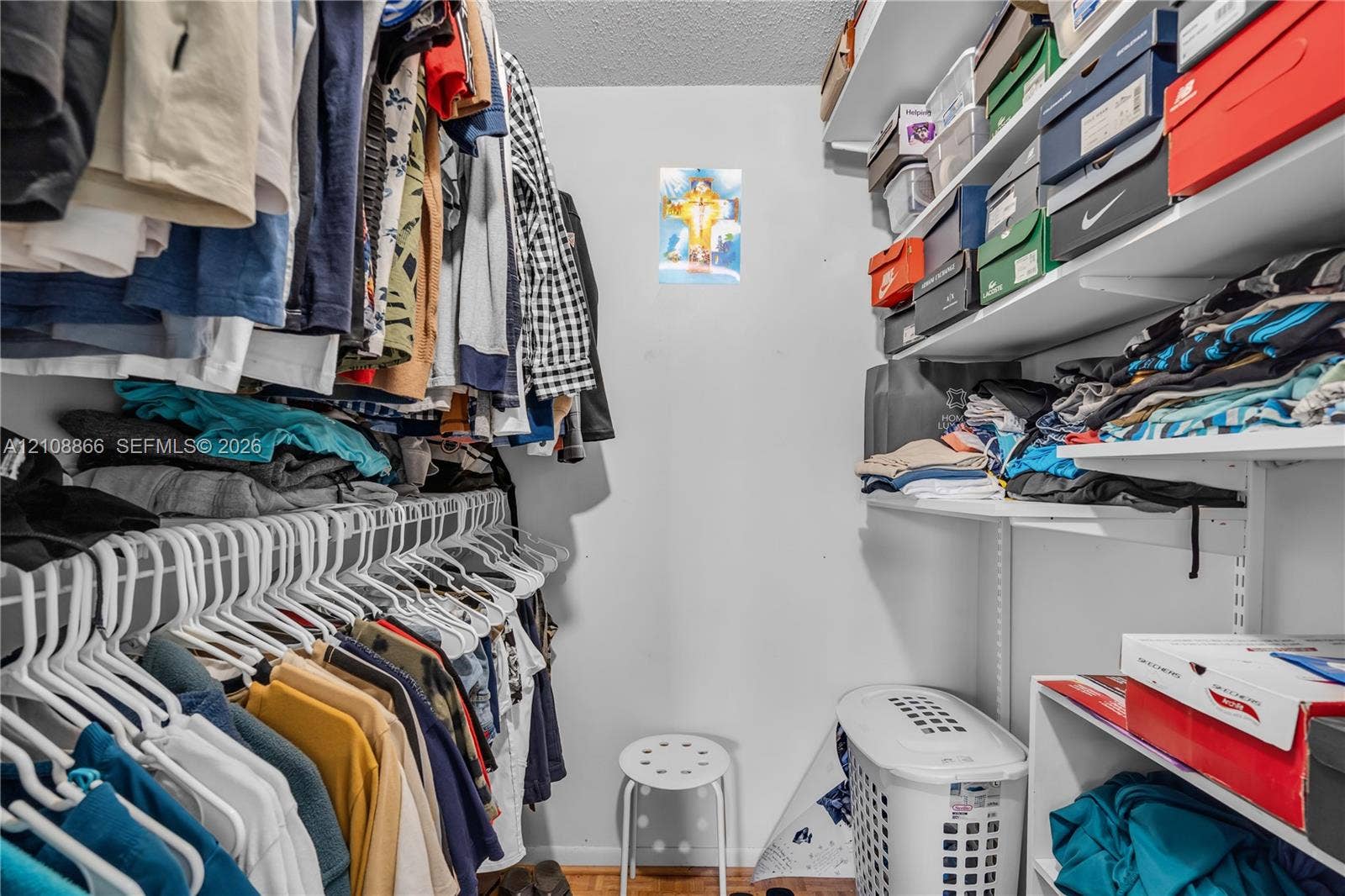 10859 NW 7th Street, #21-18, Miami, FL 33172 Walk-in closet featuring multi-tiered adjustable shelving and integrated hanging rods