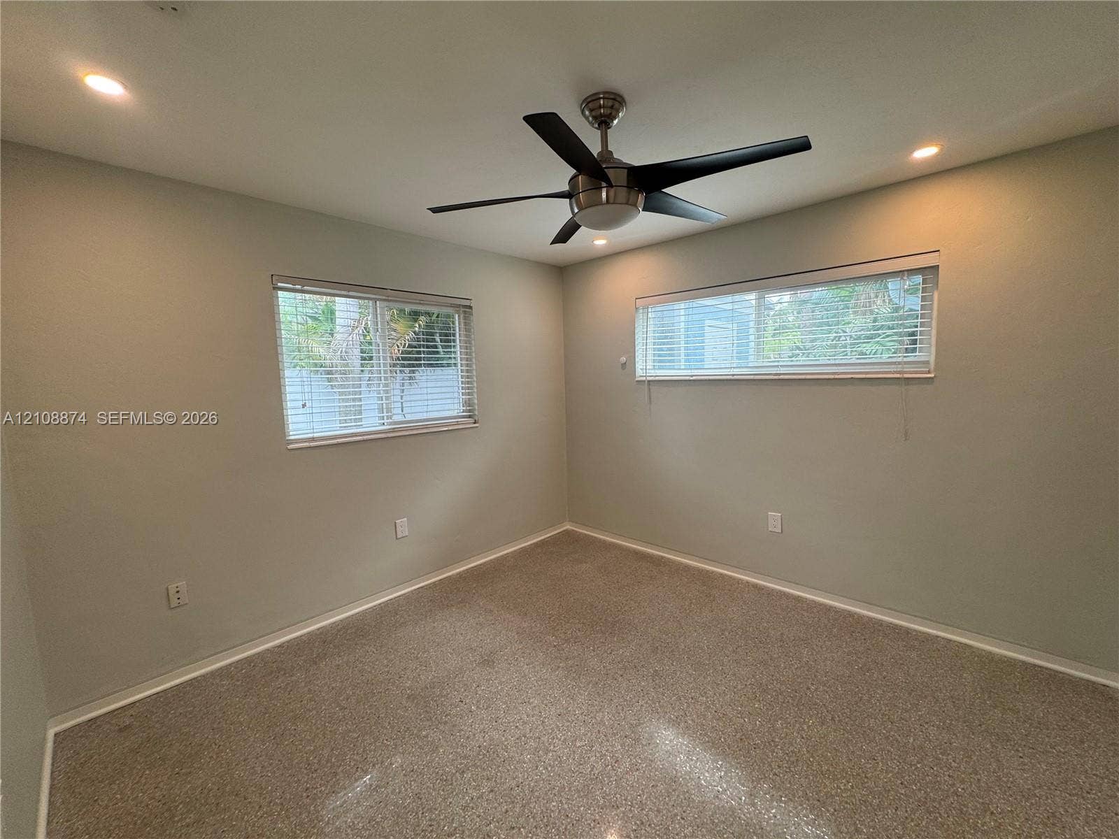 Neutral-toned walls, recessed lighting, ceiling fan with light fixture, horizontal window blinds, and speckled hard-surface flooring