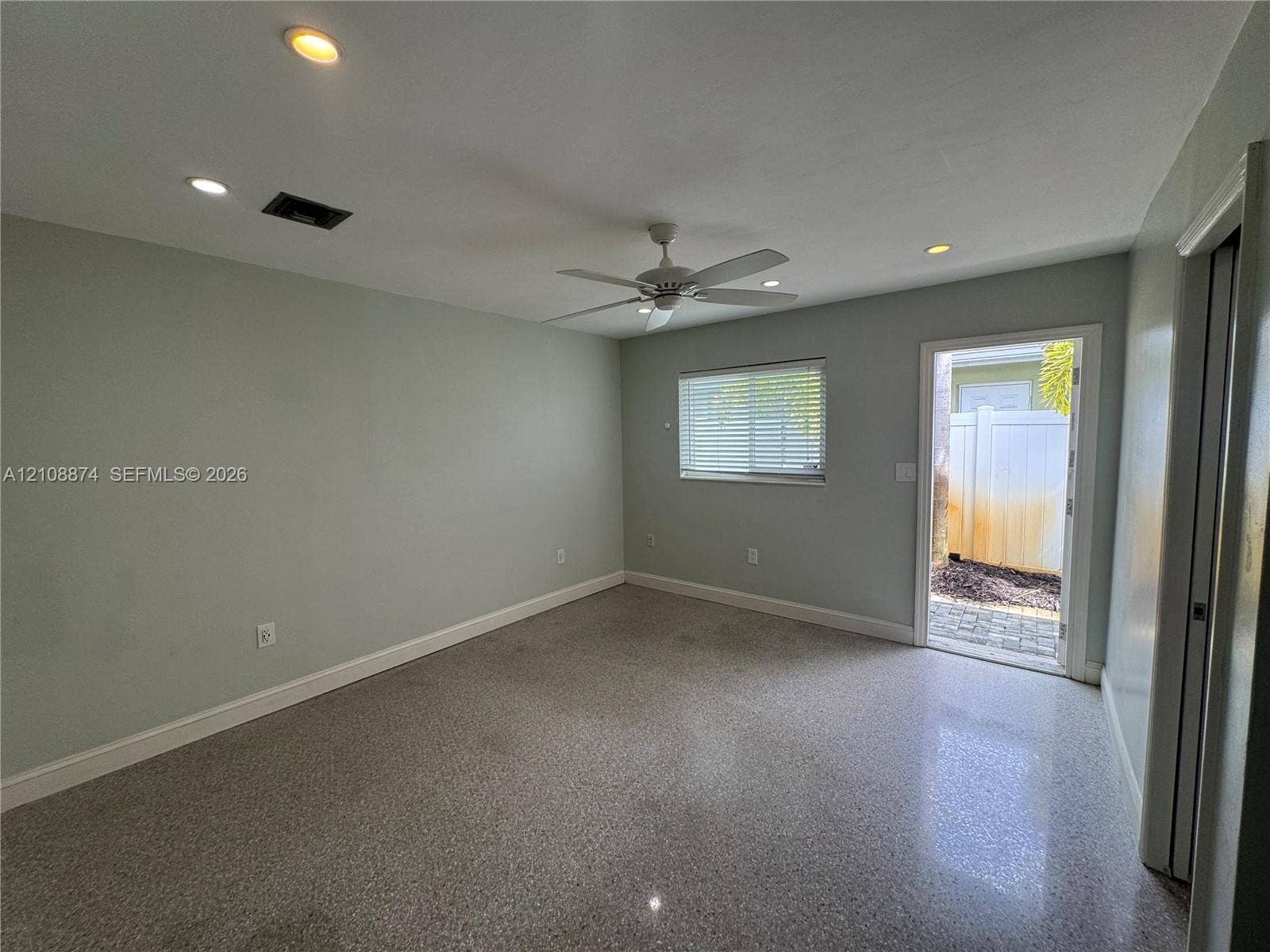 Interior space featuring speckled terrazzo flooring, recessed lighting, a ceiling fan, and direct exterior access via a glass-paneled door