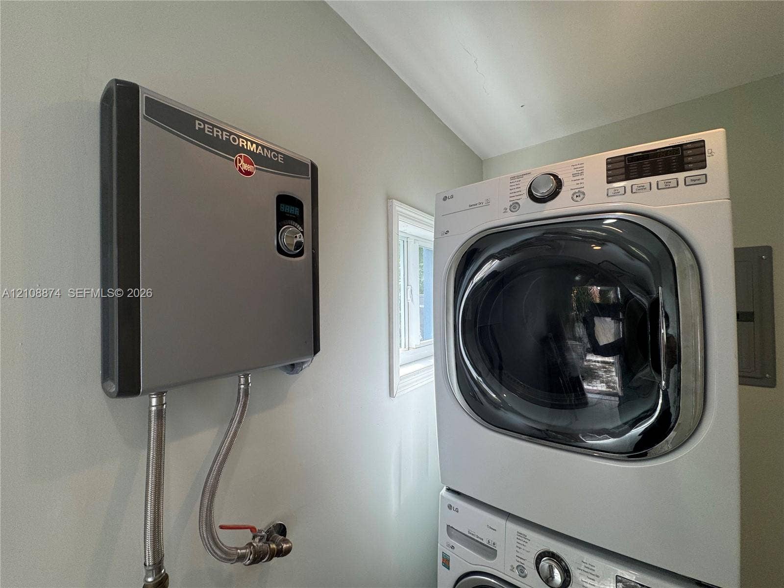 Tankless electric water heater and stacked laundry unit