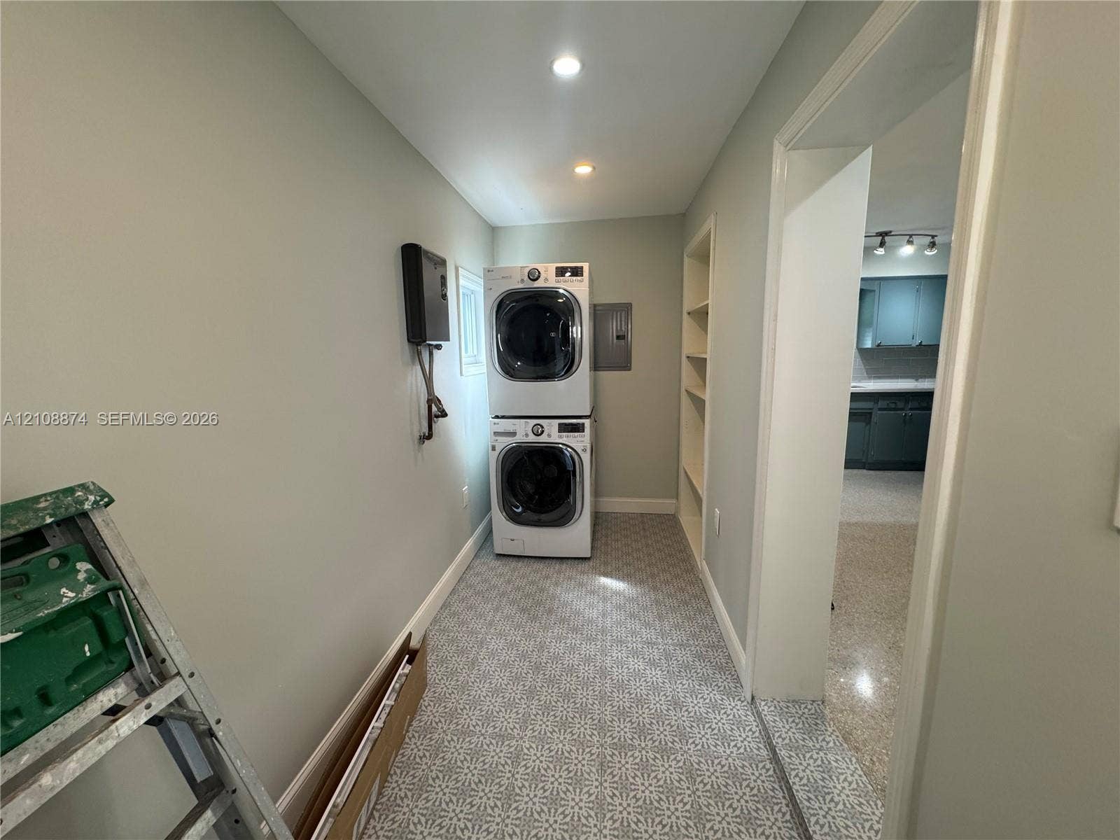 Laundry area featuring patterned tile flooring, built-in shelving, and recessed lighting