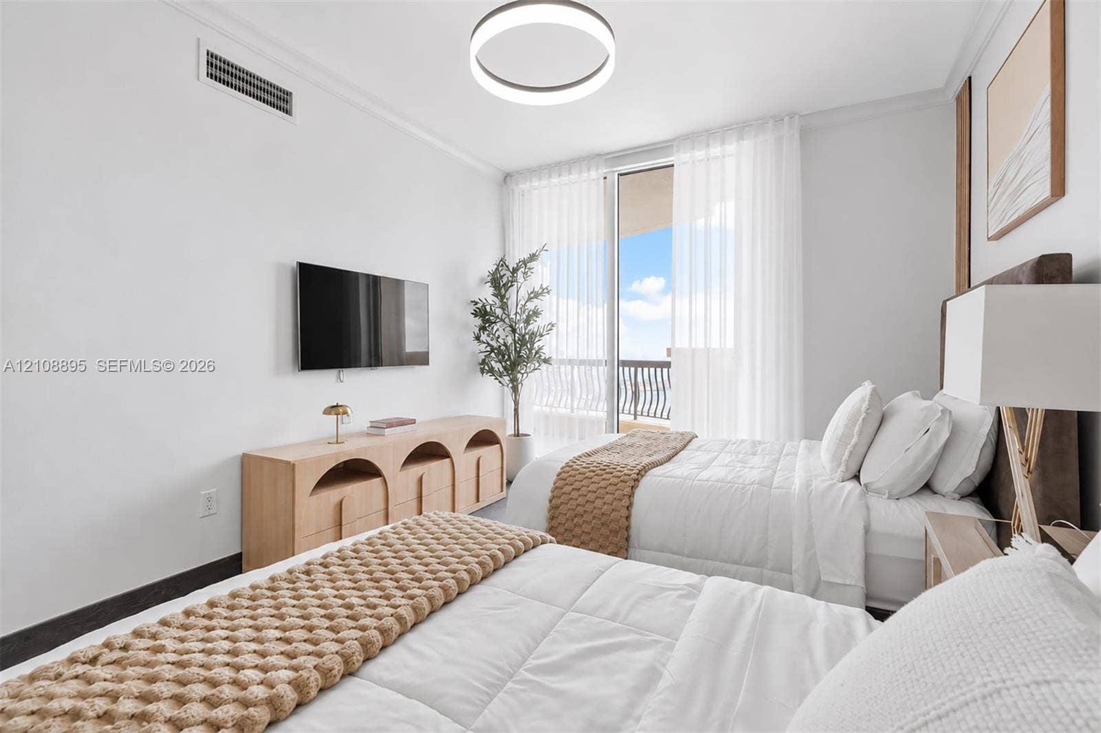 Bedroom featuring floor-to-ceiling glass sliding doors, private balcony access, modern circular LED ceiling fixture, and neutral wall finishes
