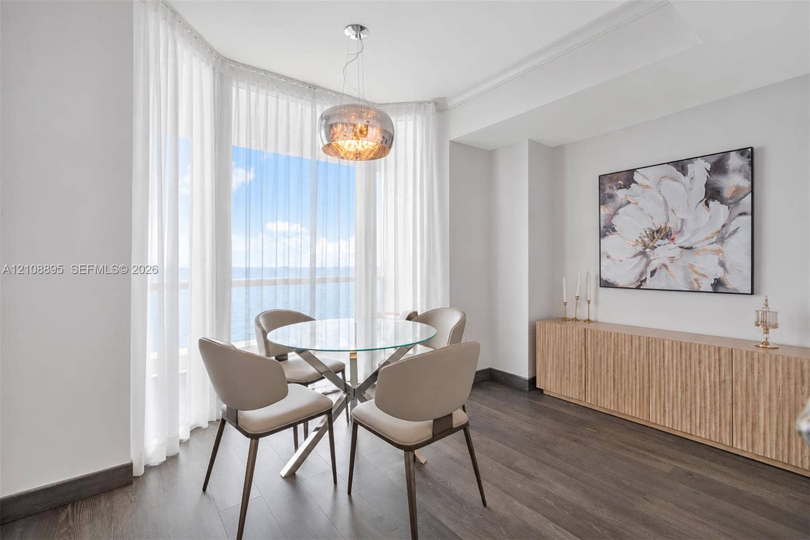 Bay window with floor-to-ceiling glass, wood-finish flooring, custom built-in cabinetry, and metallic pendant lighting