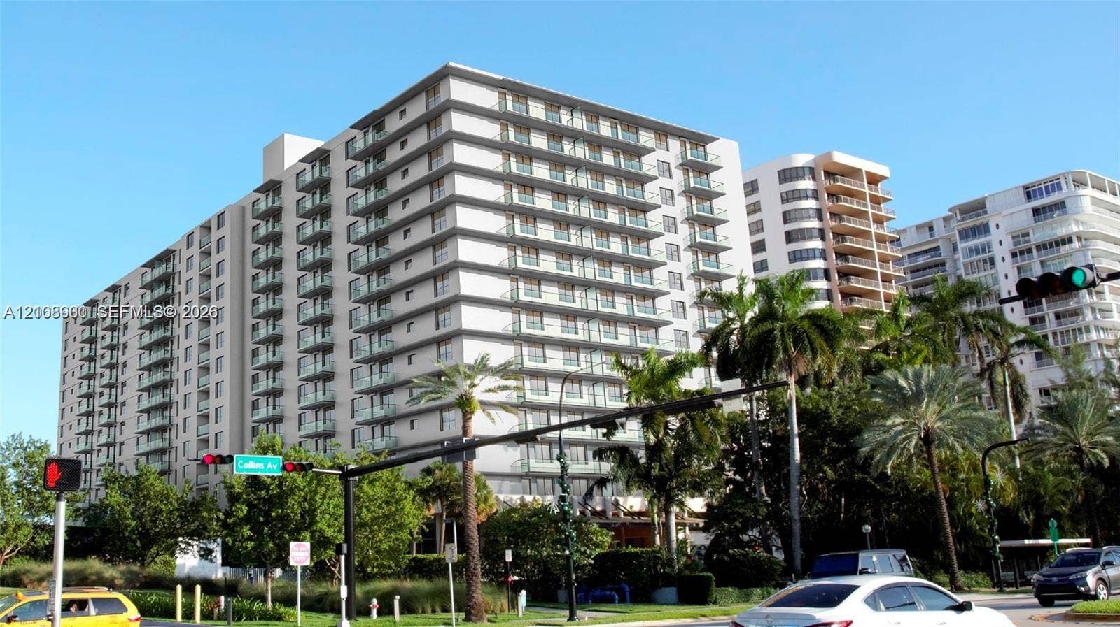 Mid-rise residential building featuring stacked balconies, concrete facade, and mature landscaping