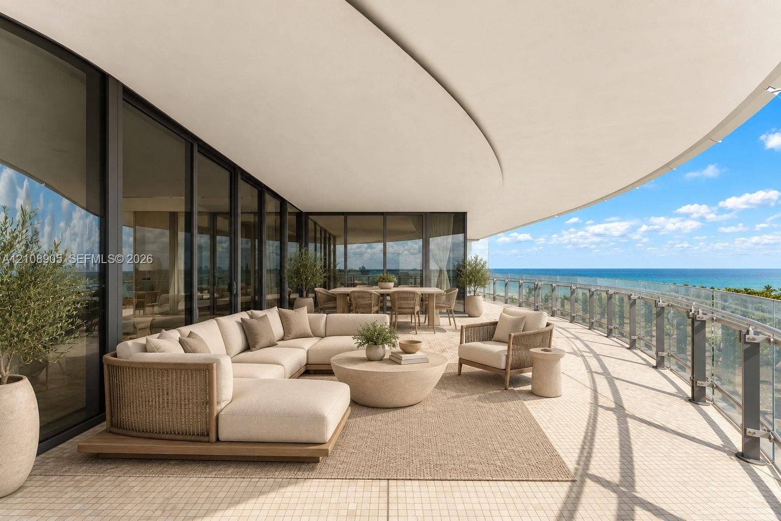 Expansive curved balcony featuring floor-to-ceiling glass doors, a continuous overhang, and glass panel railings