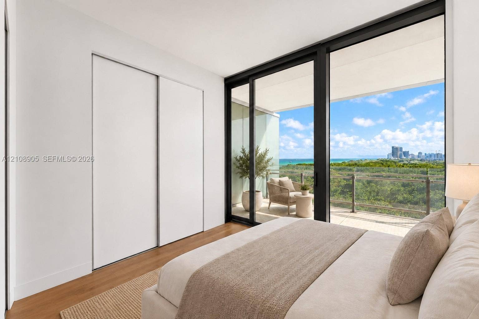 Floor-to-ceiling sliding glass doors, private covered balcony, wood-finish flooring, and built-in sliding door closet