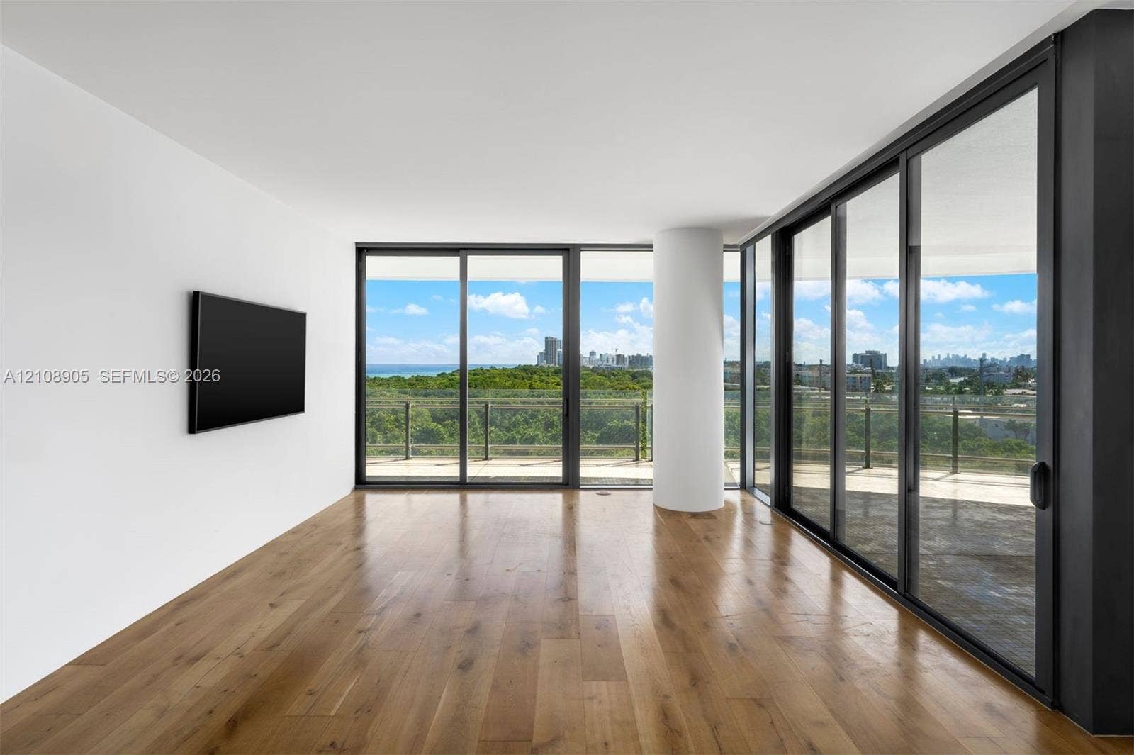 Floor-to-ceiling glass sliding doors, wood-finish flooring, structural column, and expansive outdoor terrace