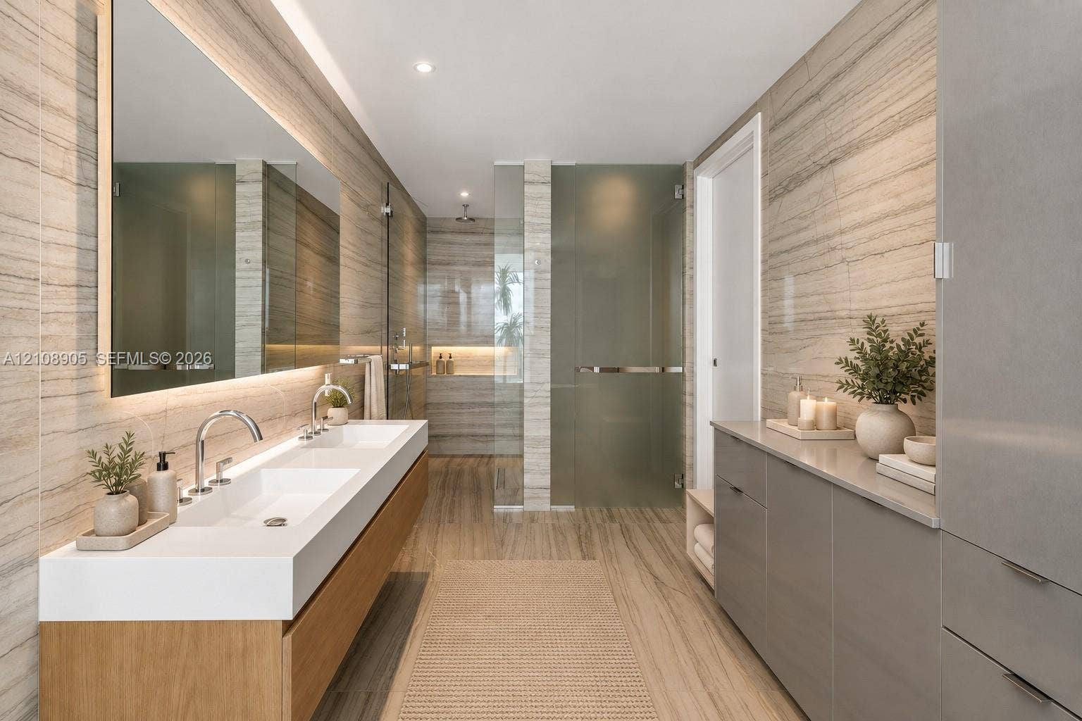 Floating wood-finish double vanity with an integrated countertop, large-format linear wall tile, oversized rectangular mirror with integrated lighting, glass-enclosed shower, and sleek built-in cabinetry