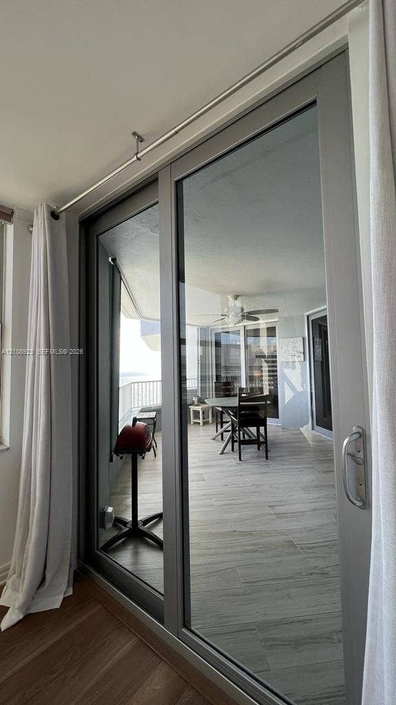 Full-height sliding glass door with a metallic frame and silver hardware, featuring a double-track system