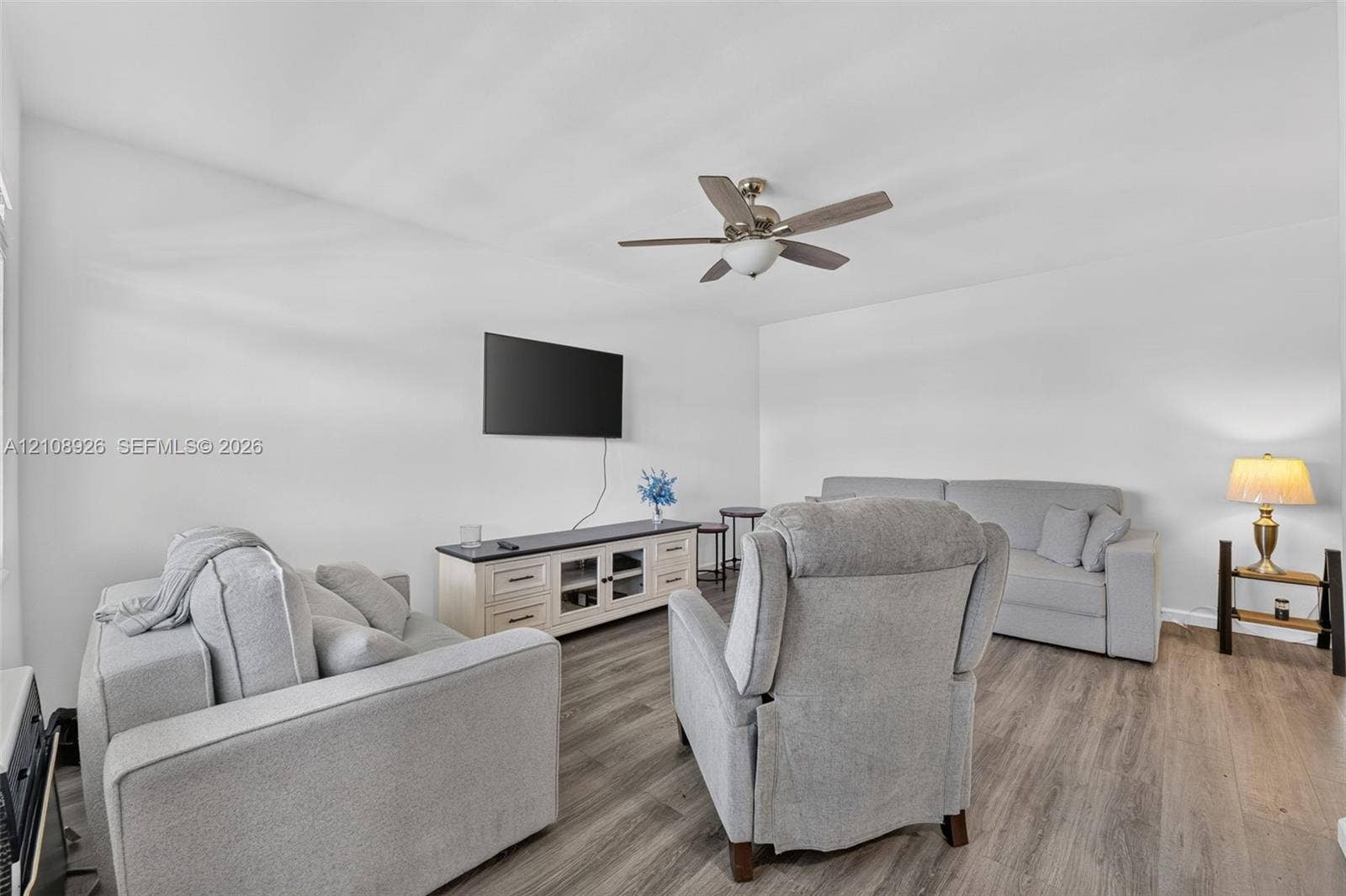 Neutral interior featuring wood-finish flooring and a central ceiling fan