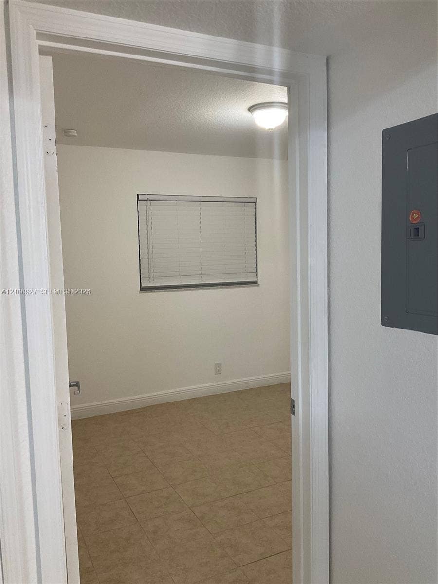 Interior room featuring tile flooring, neutral walls, window blinds, and a dome flush-mount ceiling fixture