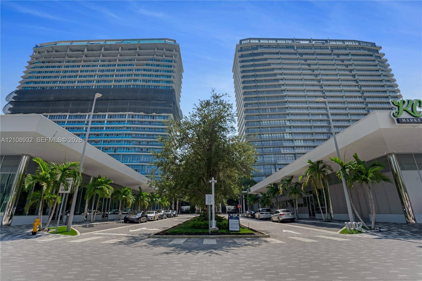 1170 E Hallandale Beach Boulevard, #1201, Hallandale Beach, FL 33009 High-rise residential towers featuring glass-curtain facades, expansive balconies, integrated ground-level retail, and professionally landscaped paved entryways
