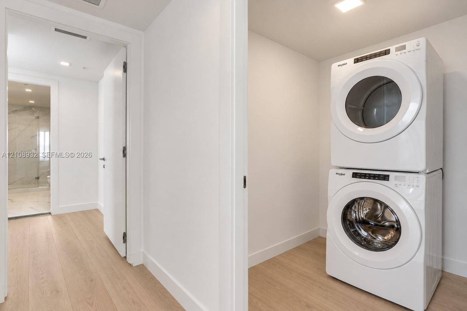 1170 E Hallandale Beach Boulevard, #1201, Hallandale Beach, FL 33009 Stacked front-loading washer and dryer, wood-finish flooring, and recessed ceiling lighting